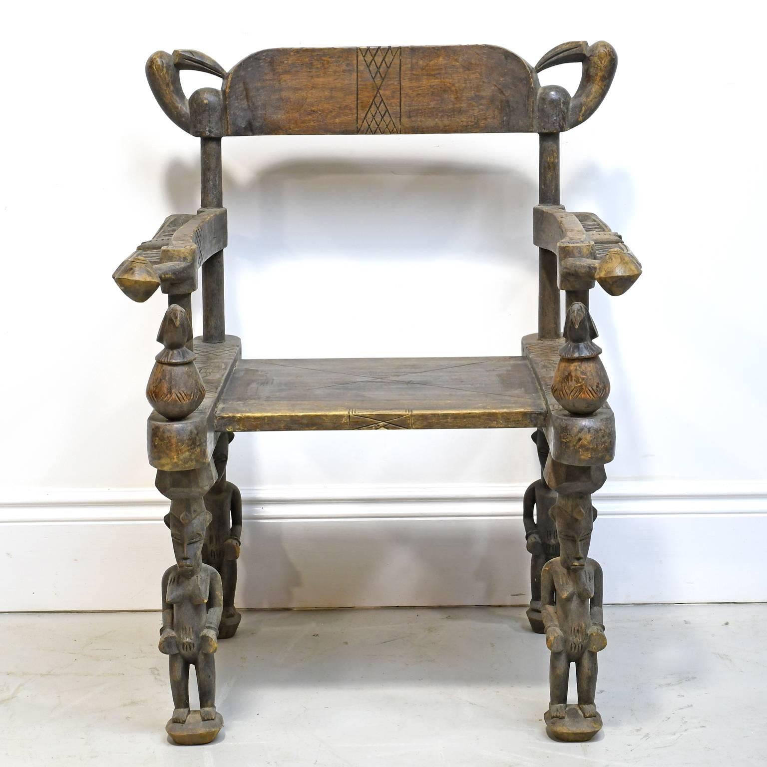 This ceremonial chair of the Senufo people is being supported by male and female fertility figures that are typical of Senufo carvings & iconography. The hornbill bird carvings on the back rest and at the ends of the arms are also fertility figures.