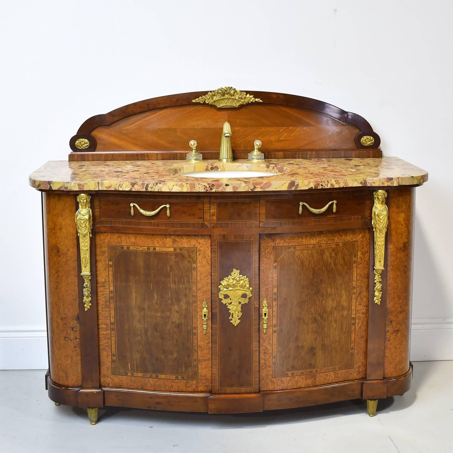 An extremely beautiful and well-crafted pair of sideboard cabinets converted for use as bathroom vanities with oval under-mount Kohler sinks and crystal-handled faucets dropped into original marble tops. From pre WWI France, these cabinets have a