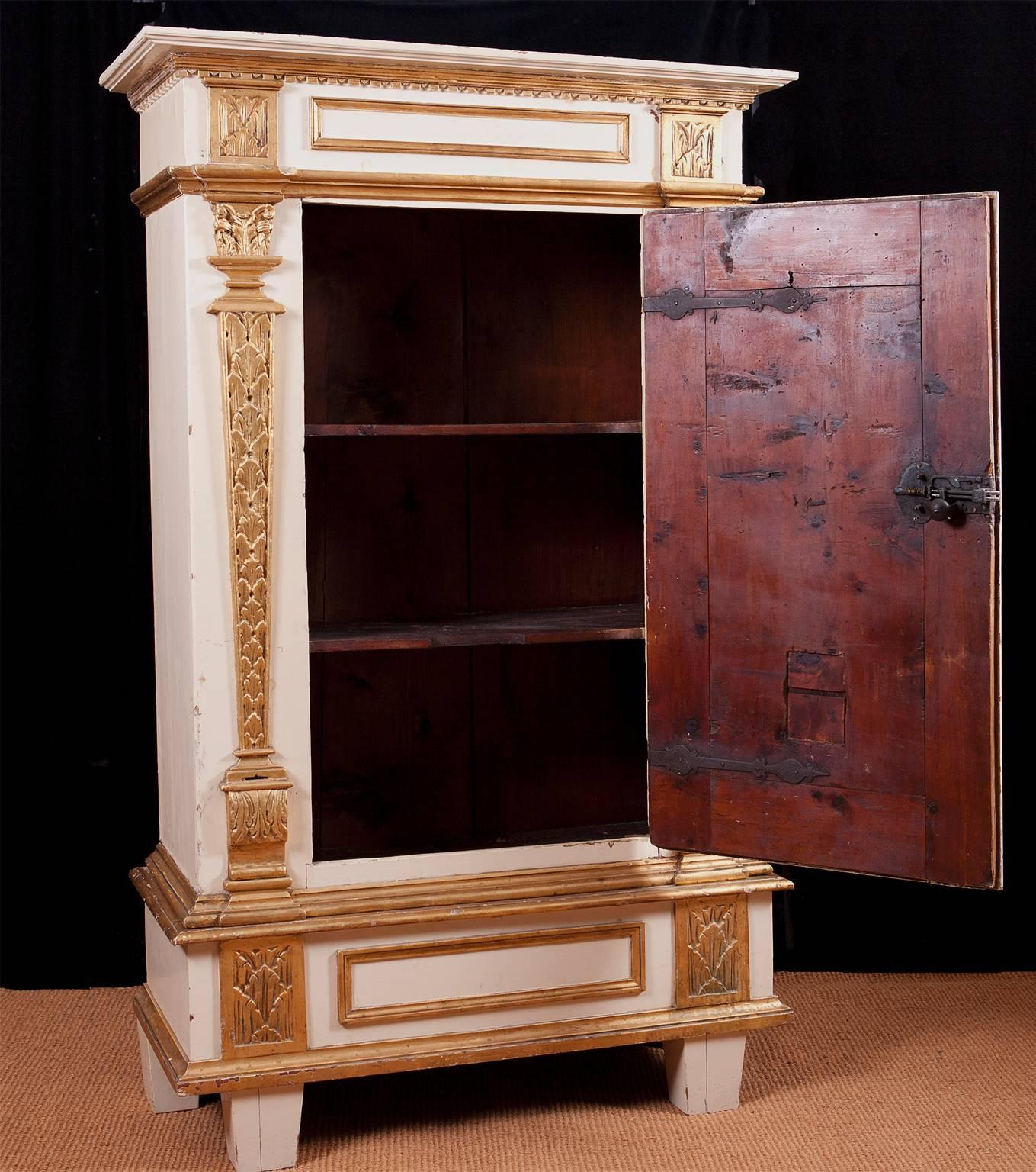 An intact baroque single-door armoire from the time of Mozart, with all its original forged iron hardware. The paint on the armoire is a 20th century European type alkyd paint as are the gold painted embellishments. The wood is Kiefer pine which is