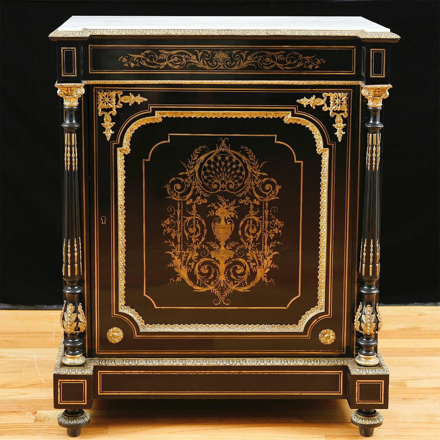 A superb Napoleon III Boulle cabinet in ebonized wood with very fine inlays in silver and brass on frieze and door panel, original white marble top, turned columns mounted with ormolu and topped with brass capitals, France, circa 1870.
Measures: