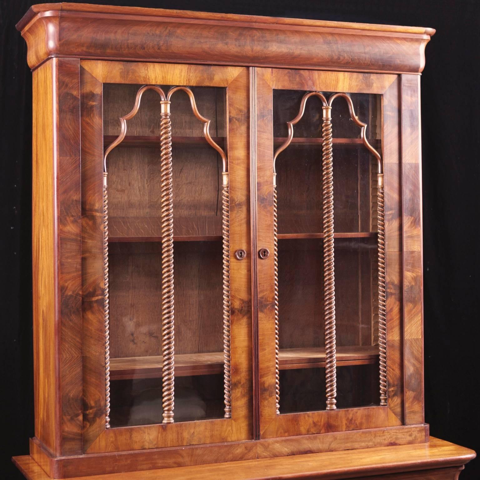 A Classic Charles X mahogany bookcase with original glass and beautifully articulated mullions. Piece is all original, including feet and turned mahogany key escutcheon plates. Comes with four keys and four original shelves for bookcase and one
