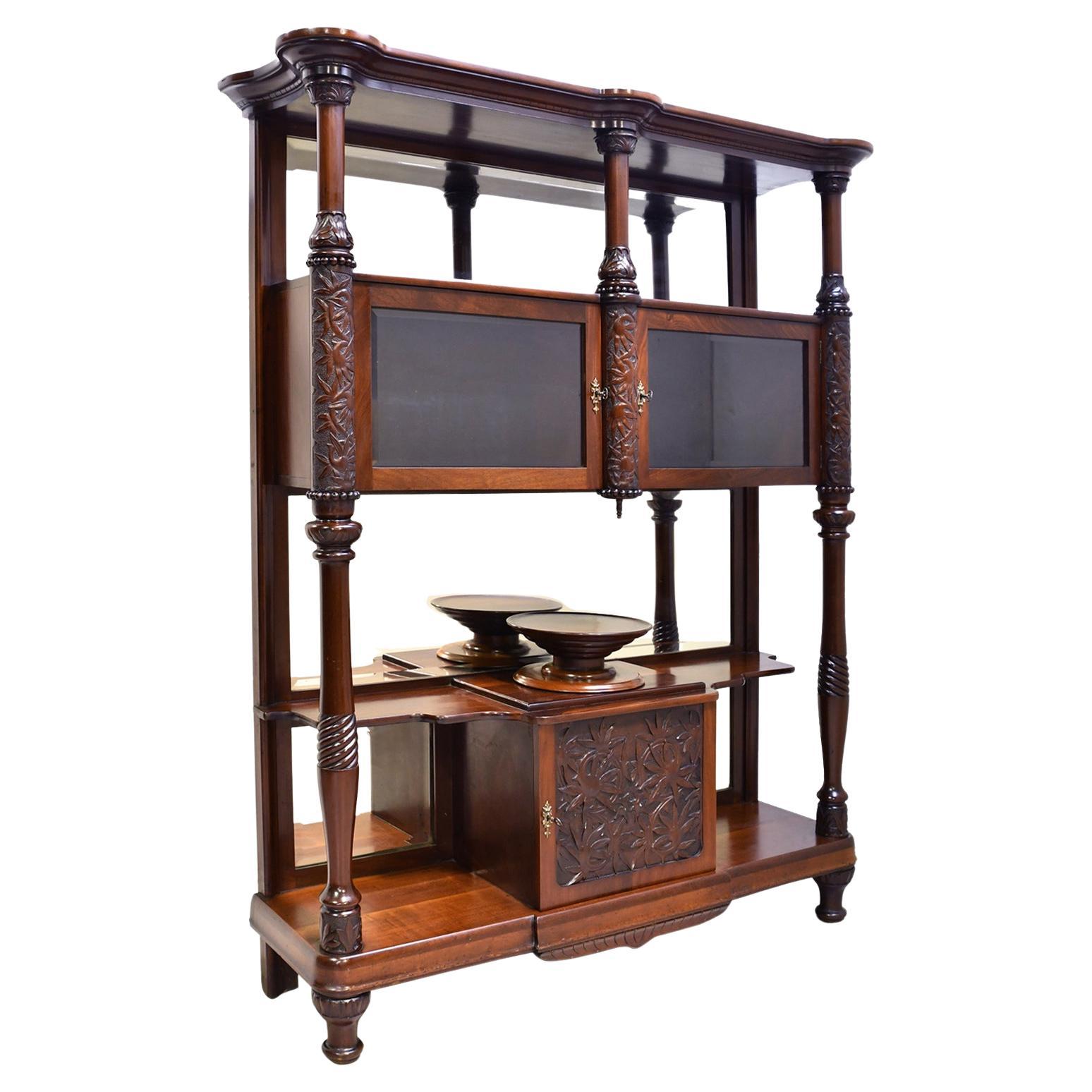 A highly unusual and very beautiful desert cupboard/ vitrine in mahogany from the Belle Époque period. This elaborate dumbwaiter offers a mirrored back with open shelving, closed storage and display areas, with a wooden lazy-Susan platter, probably