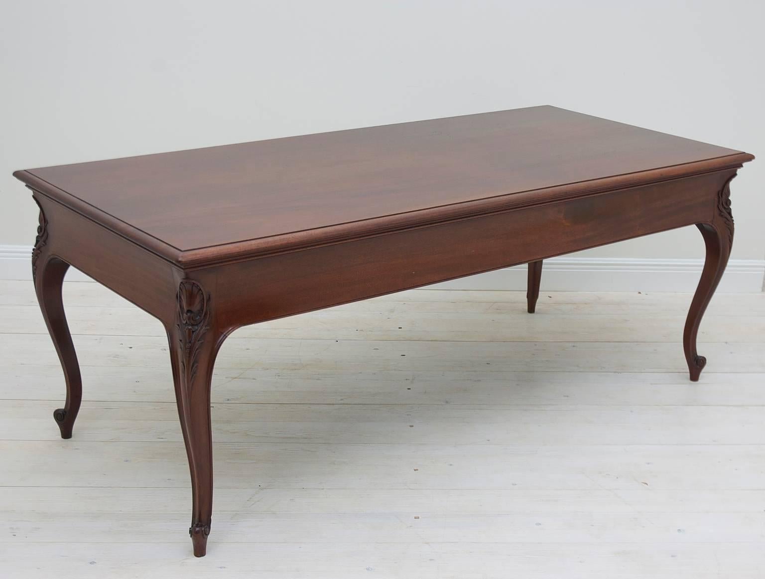 Philadelphia Centennial library table in mahogany with well-articulated foliate carvings on cabriole legs terminating in escargot feet, circa 1880. Of elegant proportions with full concave apron and solid mahogany top, this table came out of a law