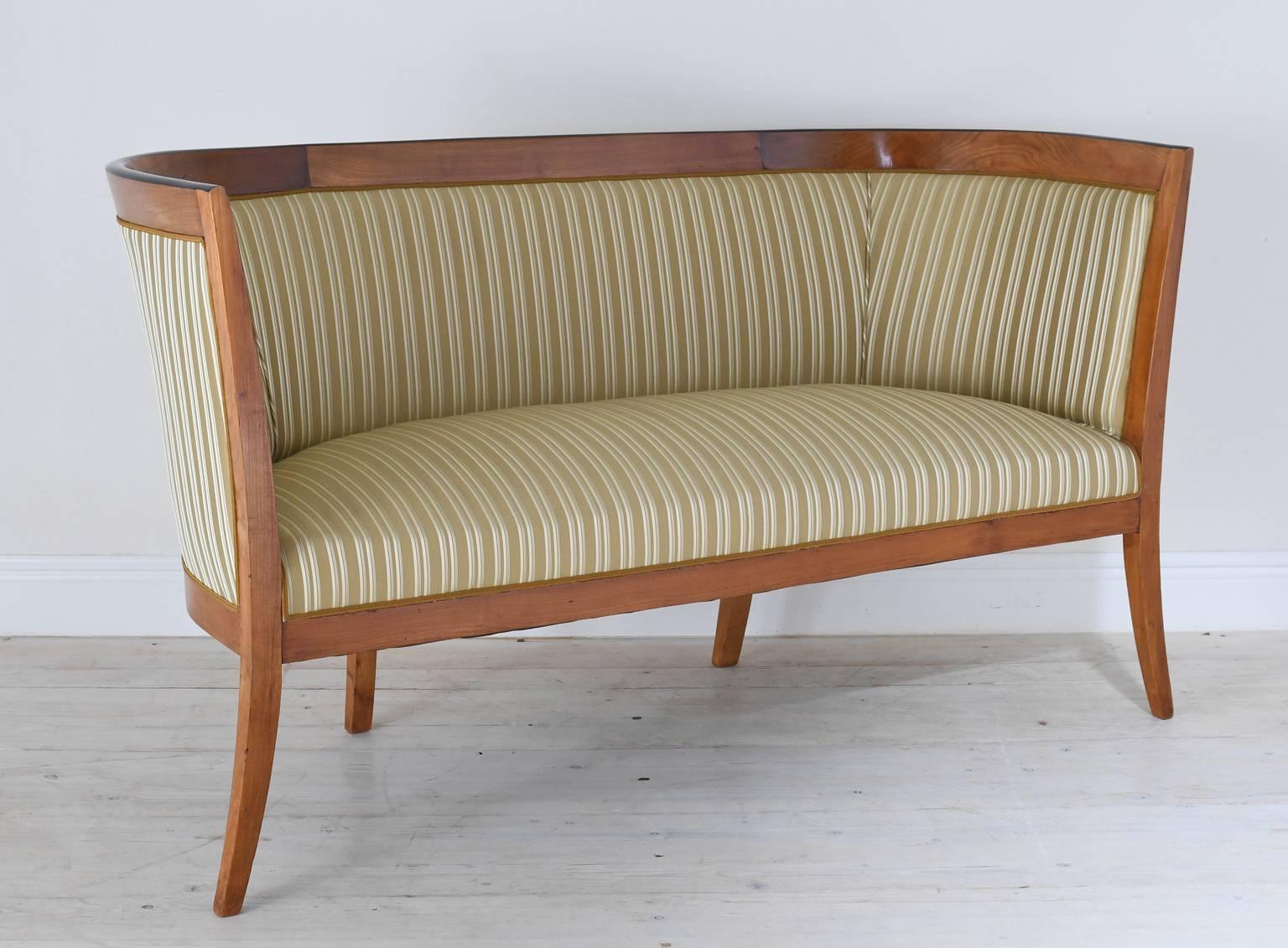 The clean Silhouette contributes to the notably understated elegance of this fine, early Viennese Biedermeier canape or settee. The cherry wood frame has an ebonized banding at the top of the crest rail subtly highlighting the sumptuous curve of the