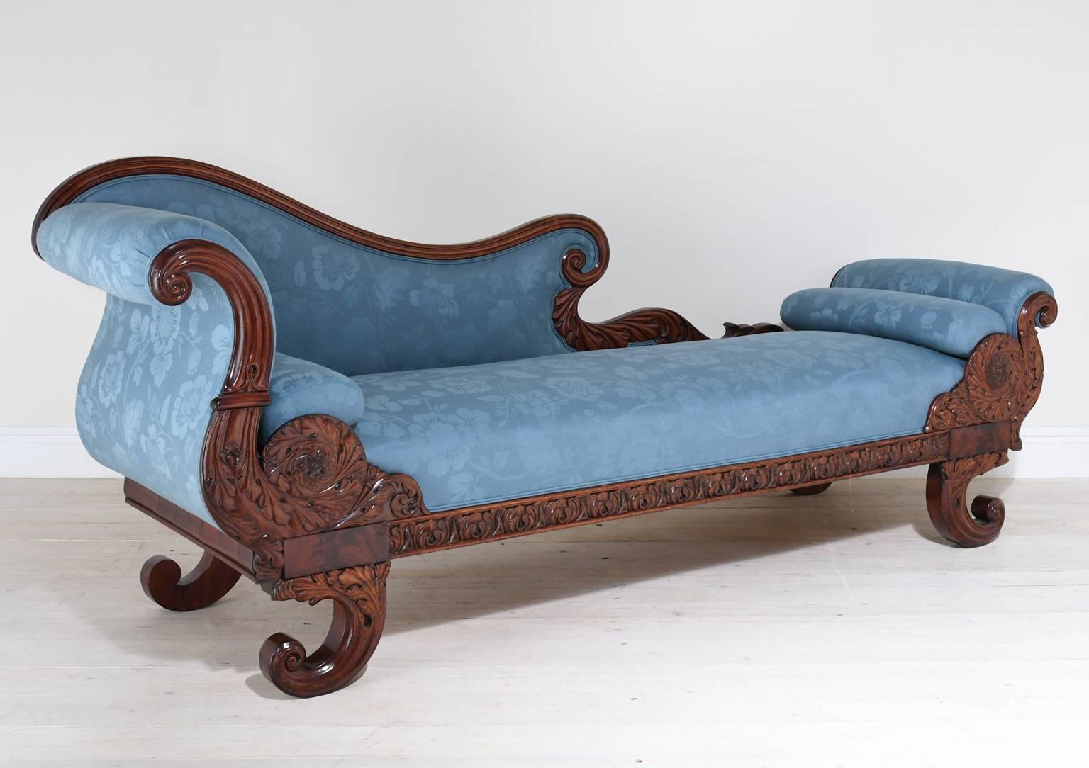 A captivating divan or chaise longue with graceful lines and fine proportions. Features scrolled arm and footrest, curved back, and cornucopia feet in mahogany, with finely carved acanthus leaves and rosettes, Northern Europe, circa 1810. A great