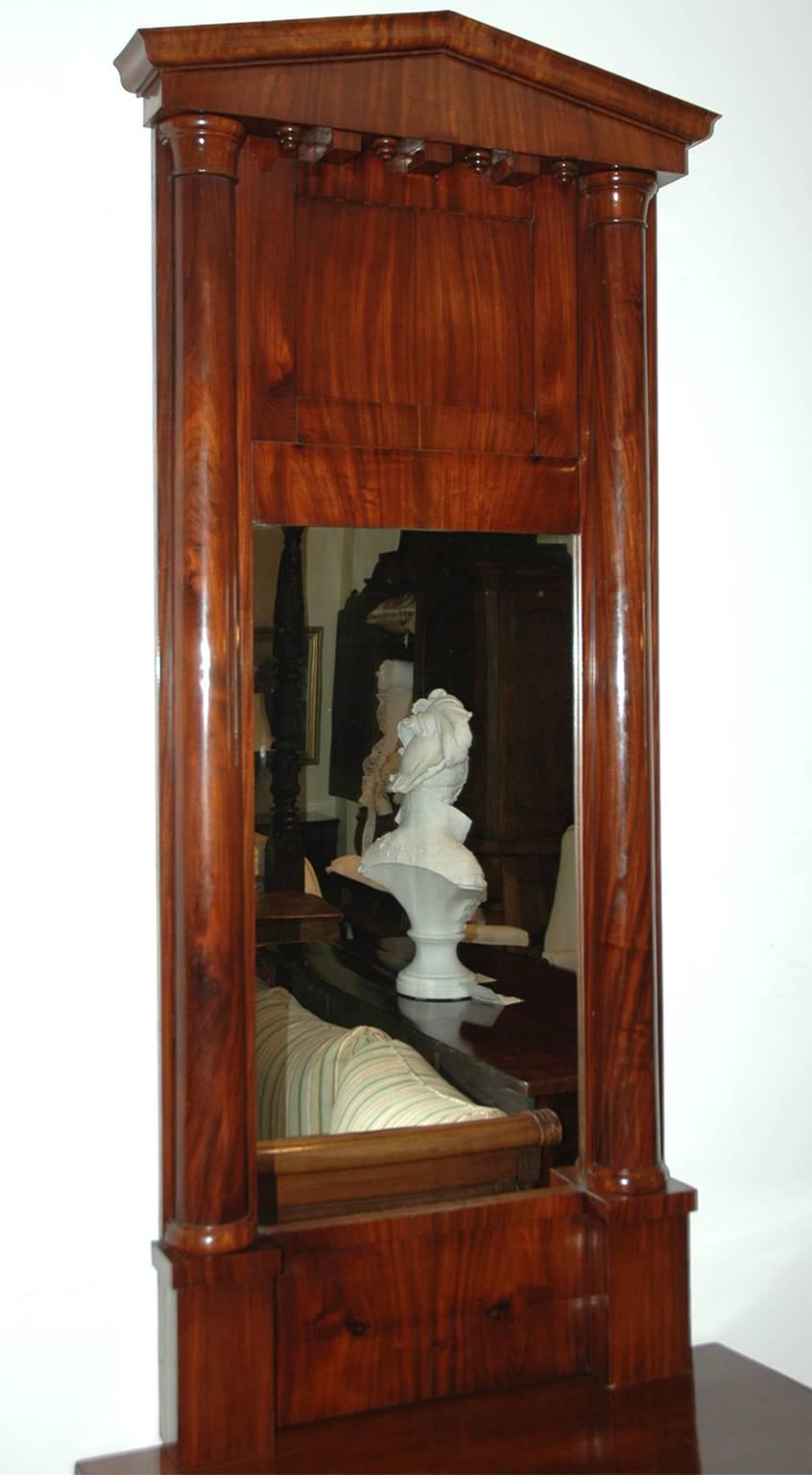 Biedermeier console mirror in figured mahogany with pediment top over two pilasters that flank mirror, Northern Germany, circa 1820.

Measures: 27 1/4