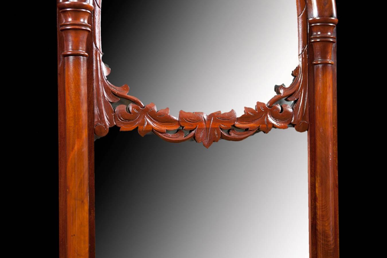Beautiful Arched Mahogany Mirror with double mirrored panels separated by a carved mahogany swag. Well articulated hand carved bonnet sits on top of an arch supported by a pair of turned pilasters, circa 1850. Great piece of workmanship, original