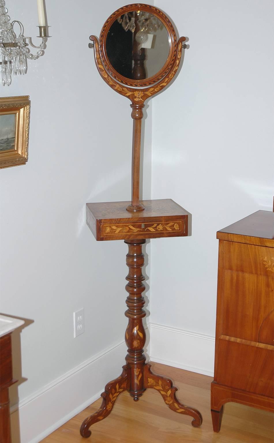 An exceptionally beautiful shaving stand in mahogany with marquetry in tulipwood and kingwood. Round mirror pivots and can be adjusted to the correct height. Turned column rests on tripod pedestal base. Holland, circa 1835. 
Measures: 20” wide, 18”