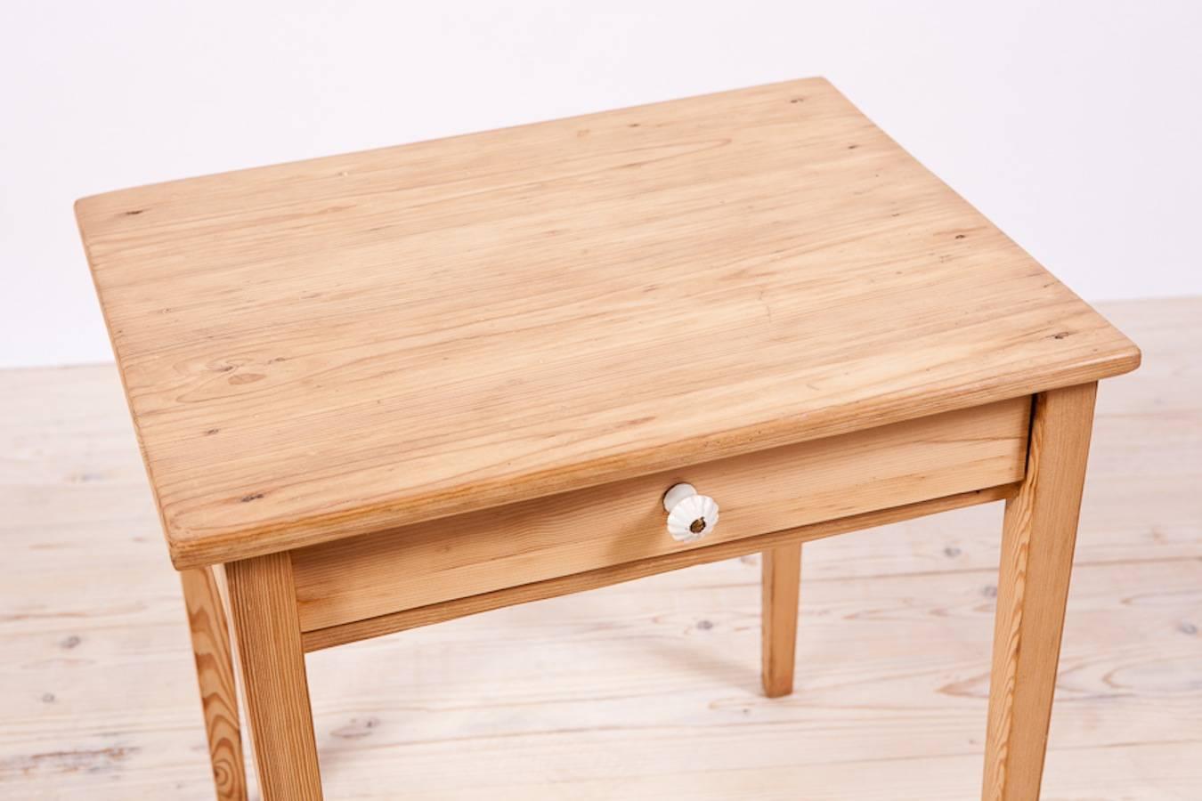 A small table in pine with square tapering legs and one drawer with porcelain pull. Northern Europe.  Table was hand-stripped of layers of paint by our workshop.

23.75