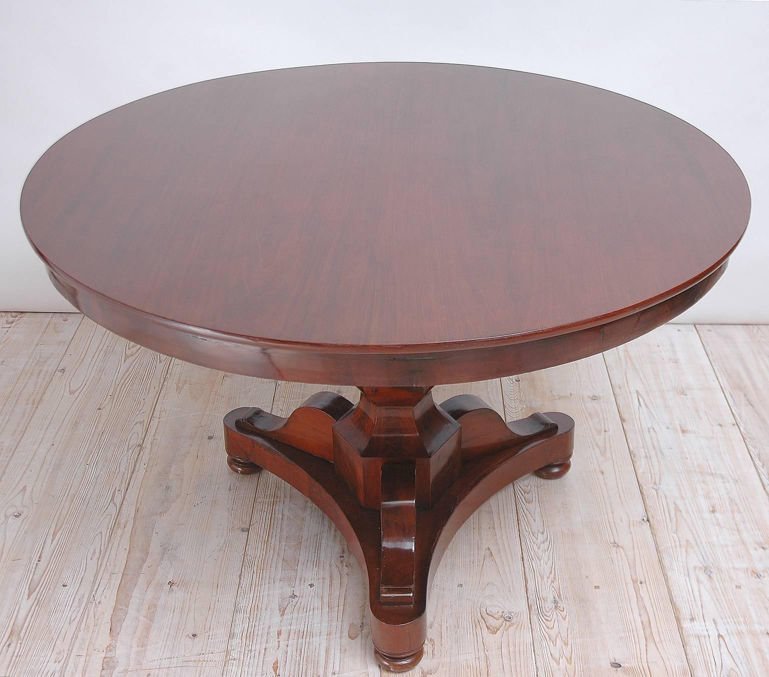 A Charles X center table in mahogany with round top on beveled baluster column resting on tripod base, France, circa 1825. 

Measures: 49