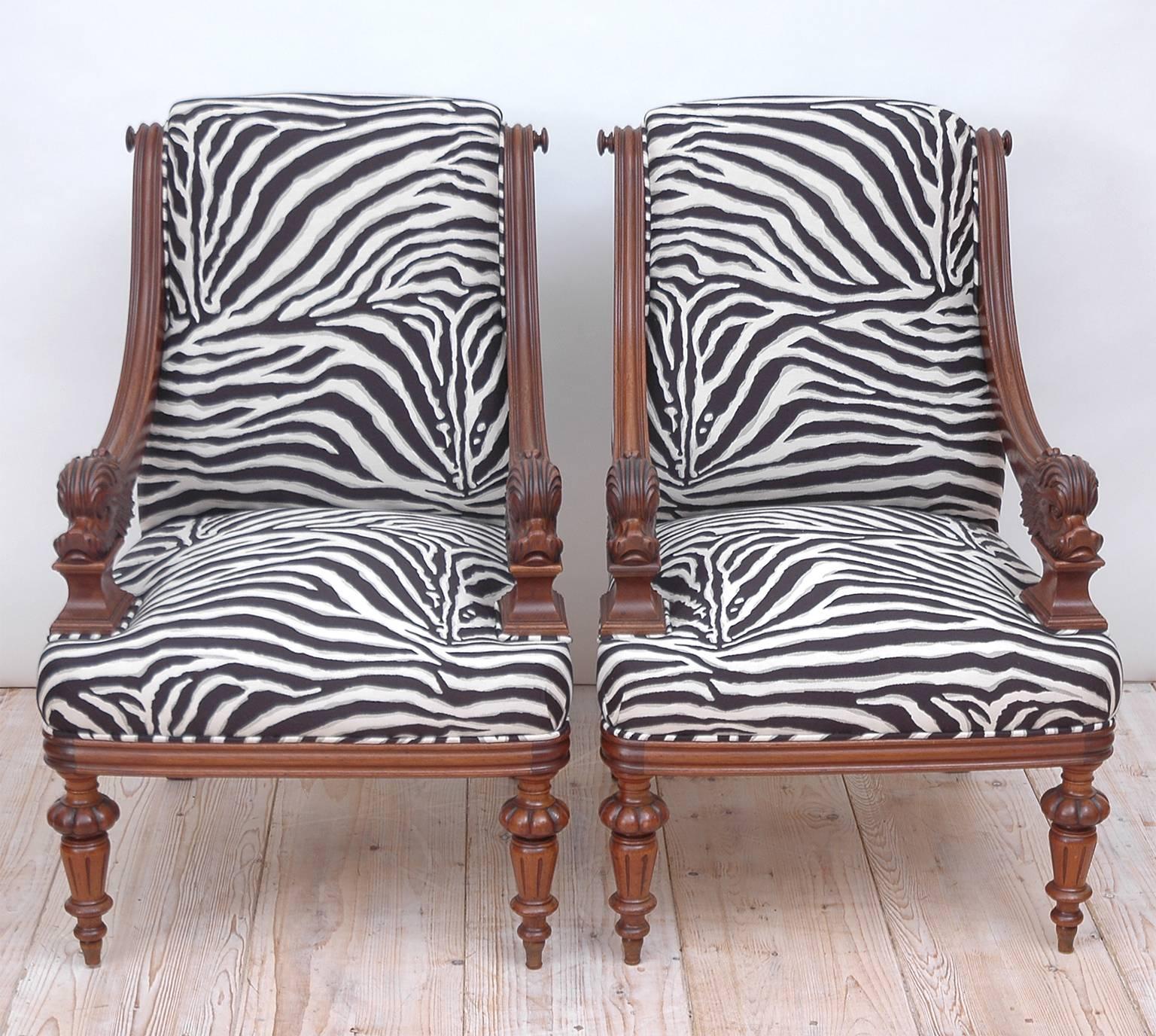 A pair of Napoleon III bergères in walnut with carved dolphins as armrests, turned and carved legs and upholstery on seat & scrolled back with finials along corners of frame. Newly upholstered in Robert Allen cotton 