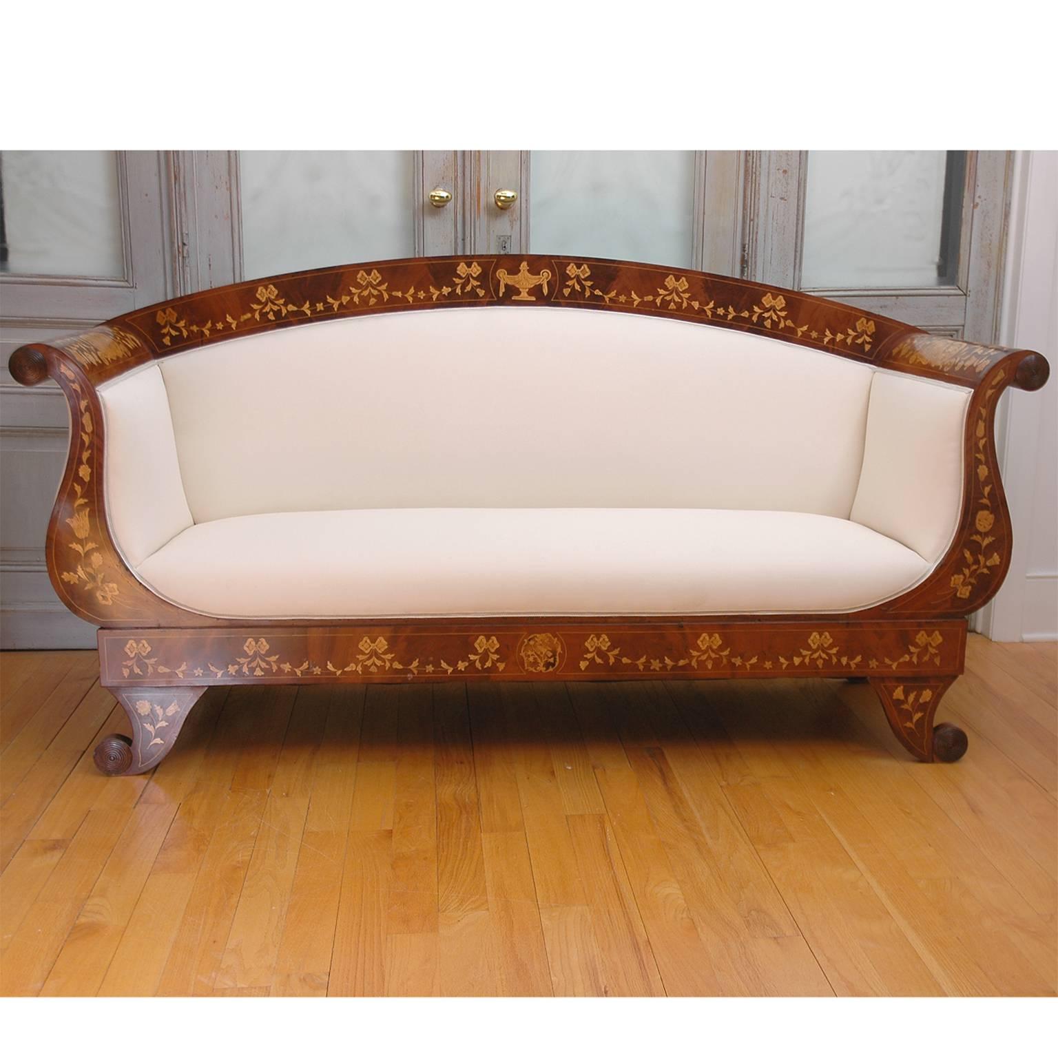 A lovely and well-proportioned marquetry sofa with arched back, scroll arms and short Grecian curved legs in mahogany embellished with inlays of festoons, bows, tulips and foliage. Northern Europe, circa 1820.
Note: You should always request a