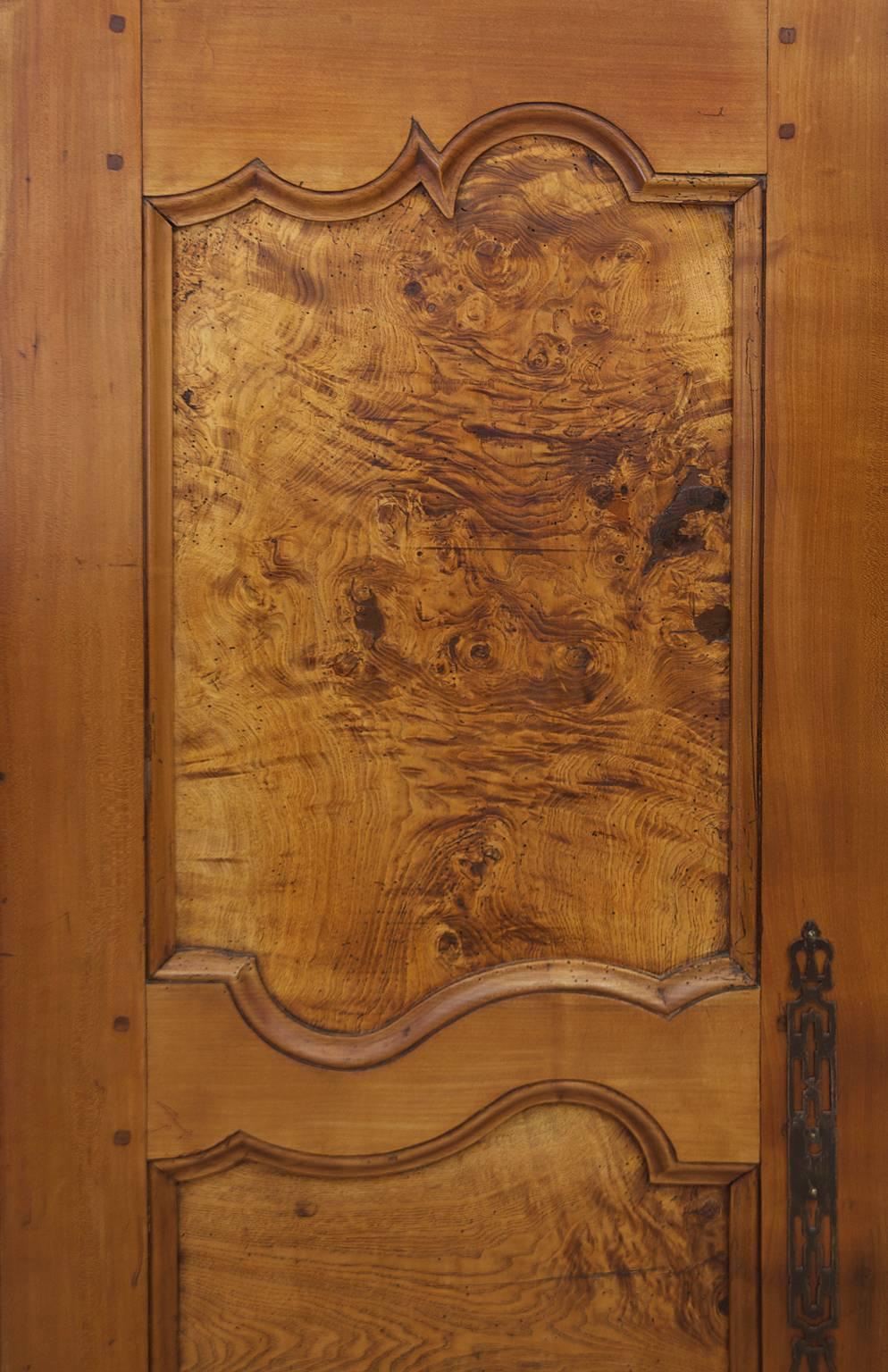 A French Armoire from Brittany in Walnut, Cherry and Oak, and Olive Ash Burl panels with mortise and peg construction, original lock, hardware and hinges, circa 1840.  Offers the potencial of ample storage for clothing, linens or as a cupboard or