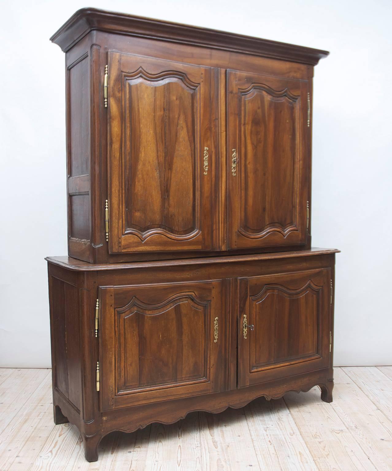 An 18th century buffet a deux corps in walnut with a cabinet resting above another cabinet and terminating on short carved cabriole legs with carved apron. Features original brass hardware, with working locks and key, France, circa late 1700s.
Note: