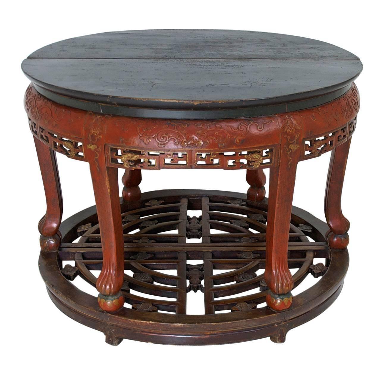From Shanxi province of China, a handsomely carved pair of half-moon tables that can be used separately or together to form a round center table. Offers a black-lacquered top with carved convex apron on cabriole legs with carved lion's paw feet