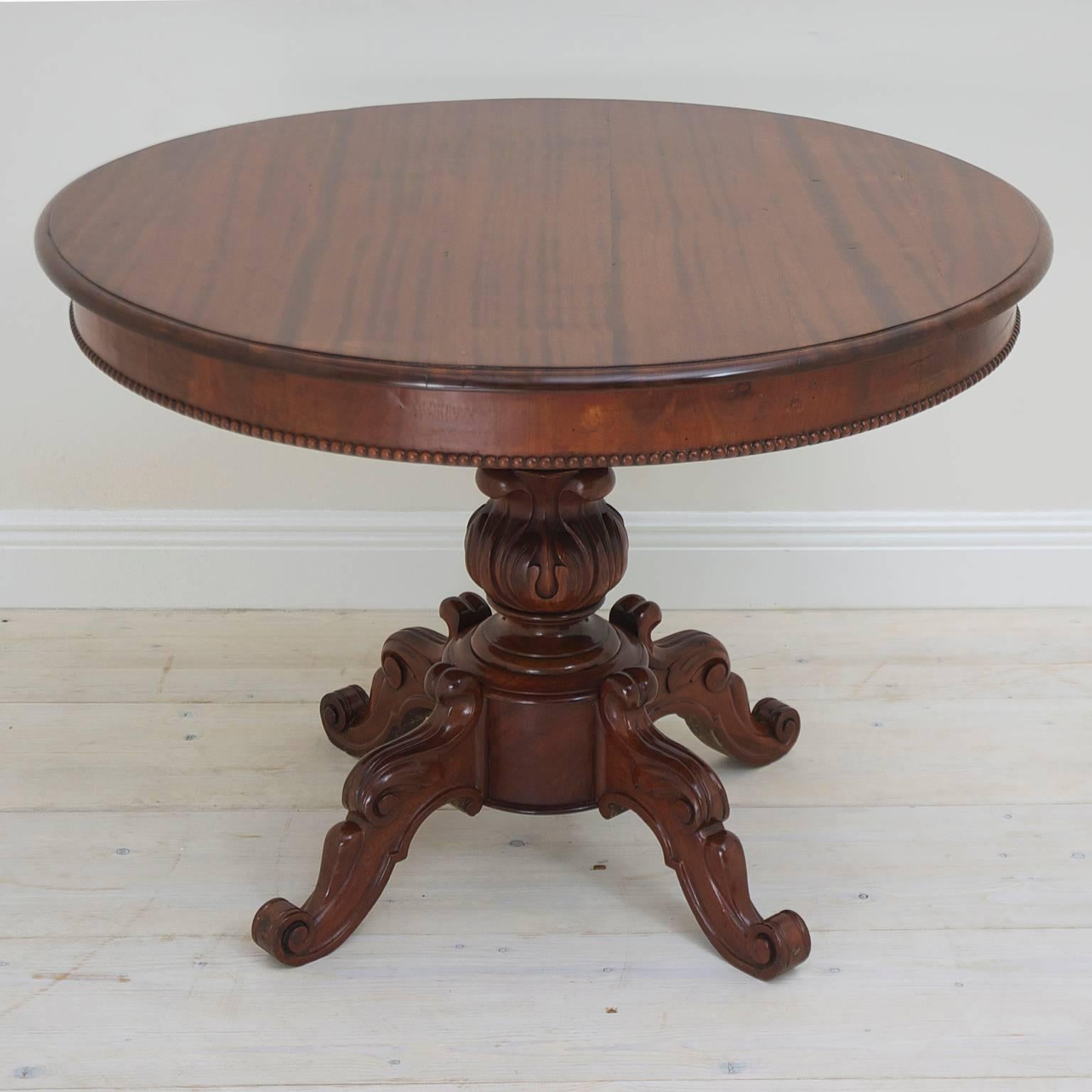 A fine Louis Philippe center or end table in mahogany with round top resting on baluster-turned pillar with carved foliate design and ending in four carved legs with scrolled feet. France, circa 1835.

Makes a beautiful end table, or a center