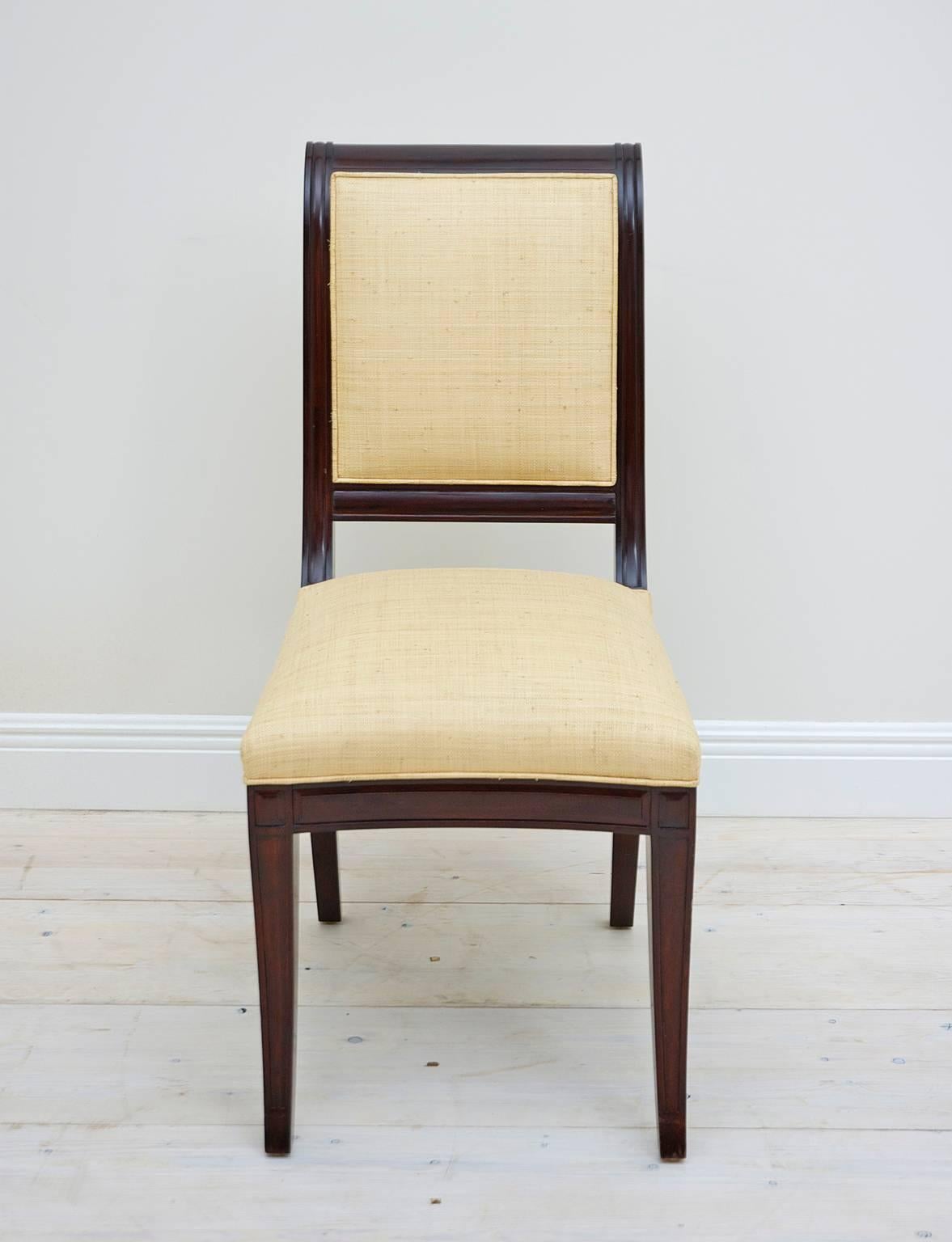 A set of 12 very impressive, handmade early 20th century British colonial dining chairs in the Empire style are upholstered in woven Madagascar and fabricated out of very fine and dense mahogany. Chairs are have an impressive weight and are