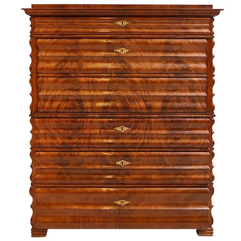 A captivating one of a kind Louis Phillip secretary in book-matched, flame mahogany with shaped, curvi-linear drawer fronts and faux drawer fronts on the fall-front and the sides. Offers four hidden compartments for valuables, Northern Germany,