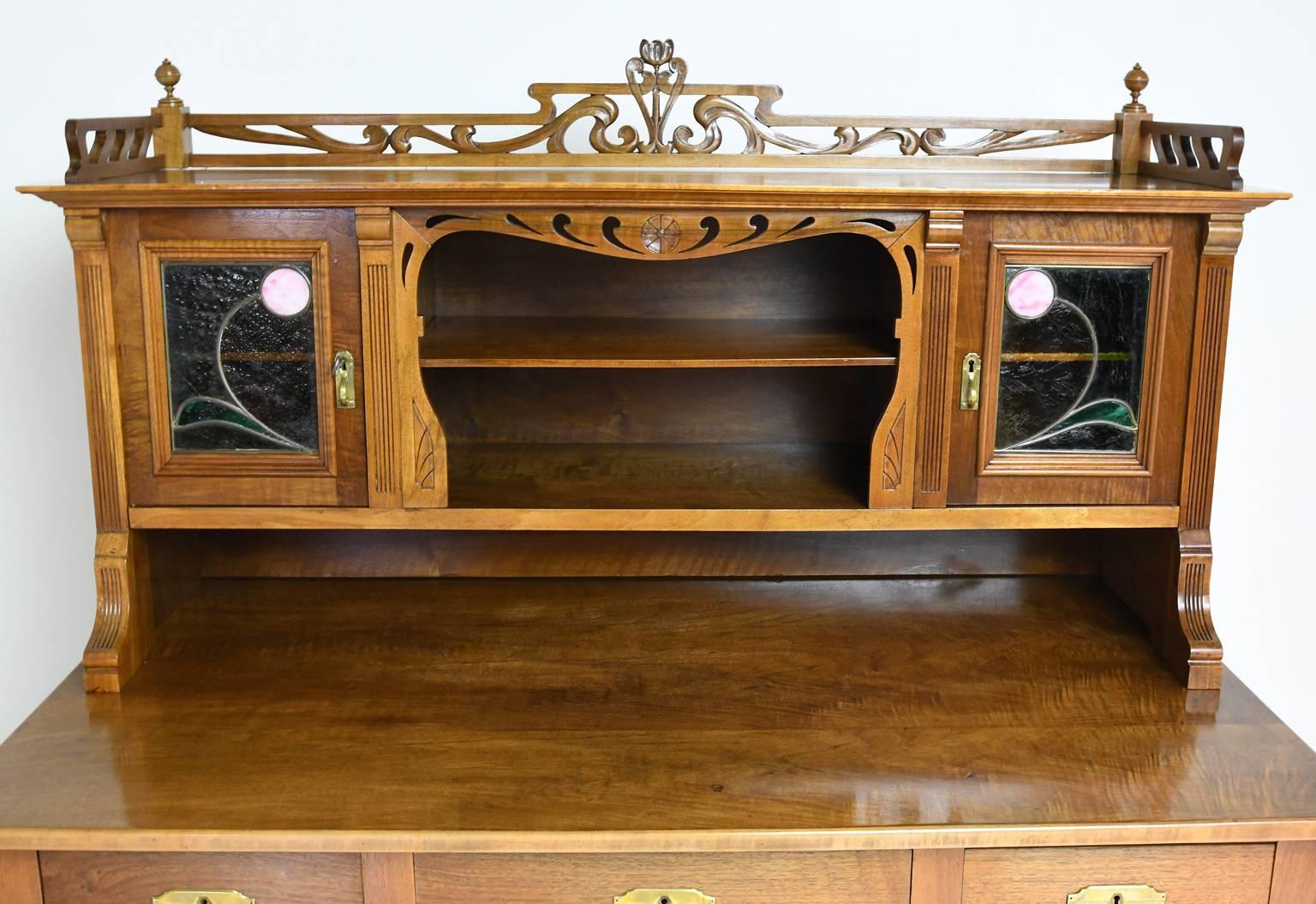 A beautiful Art Nouveau pedestal desk in walnut with cabinets at either side of knee-hole opening to offer six storage drawers, in addition to the three drawers along the apron. The small bookcase resting over the rear top features a gallery with