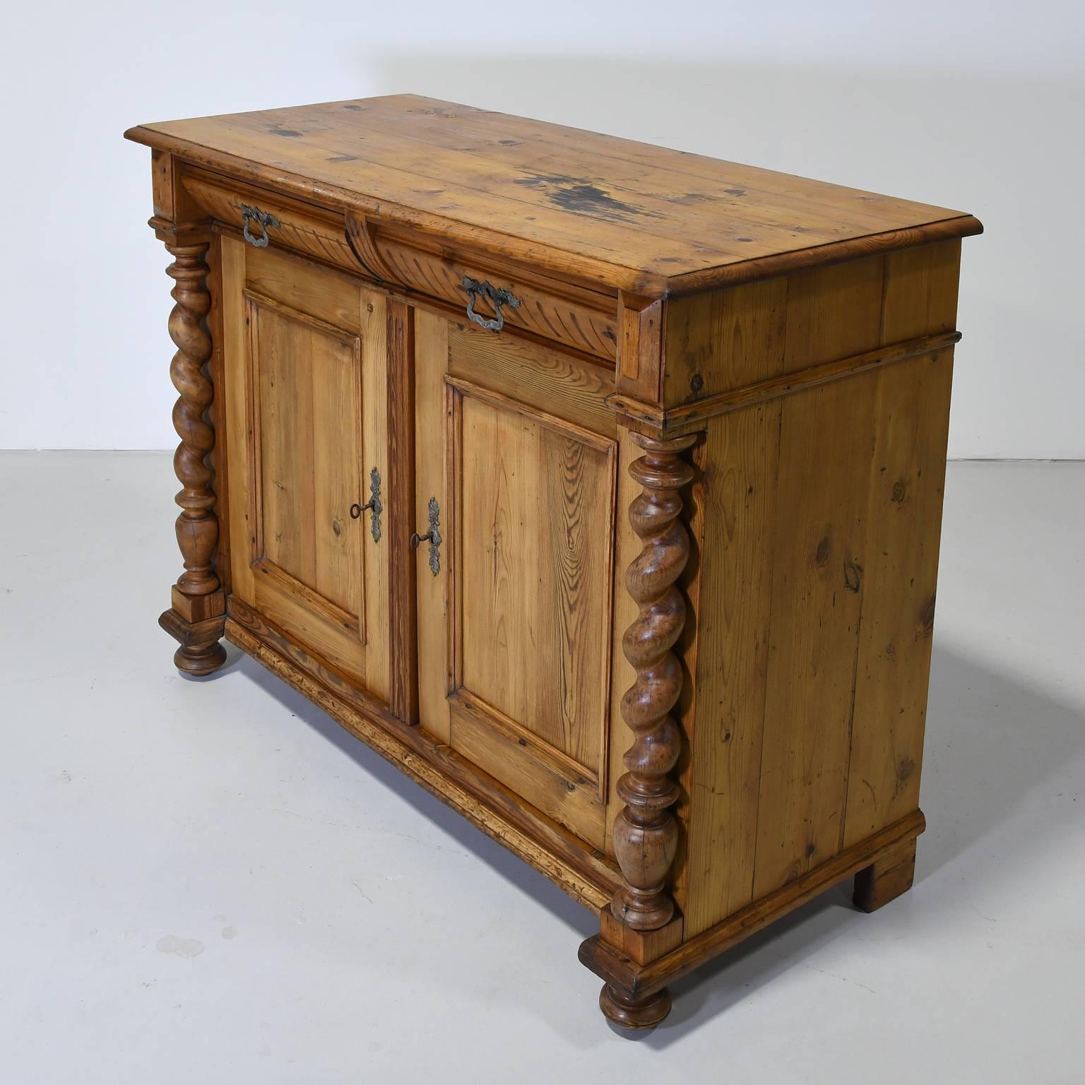A Danish server in pine with two convex fluted drawers over two cabinet doors and rope-turned columns flanking each. Scandinavian or German, circa 1860. Cabinet doors open independent of each other featuring original interior shelving on both sides.