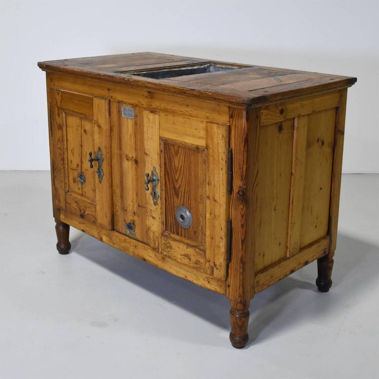 A rare precursor to our modern refrigerator and freezer, this rustic cabinet in pine has an interior that is lined with zinc and a central compartment where the ice was kept, Northern Europe, circa mid to late 1800s. It features original hardware