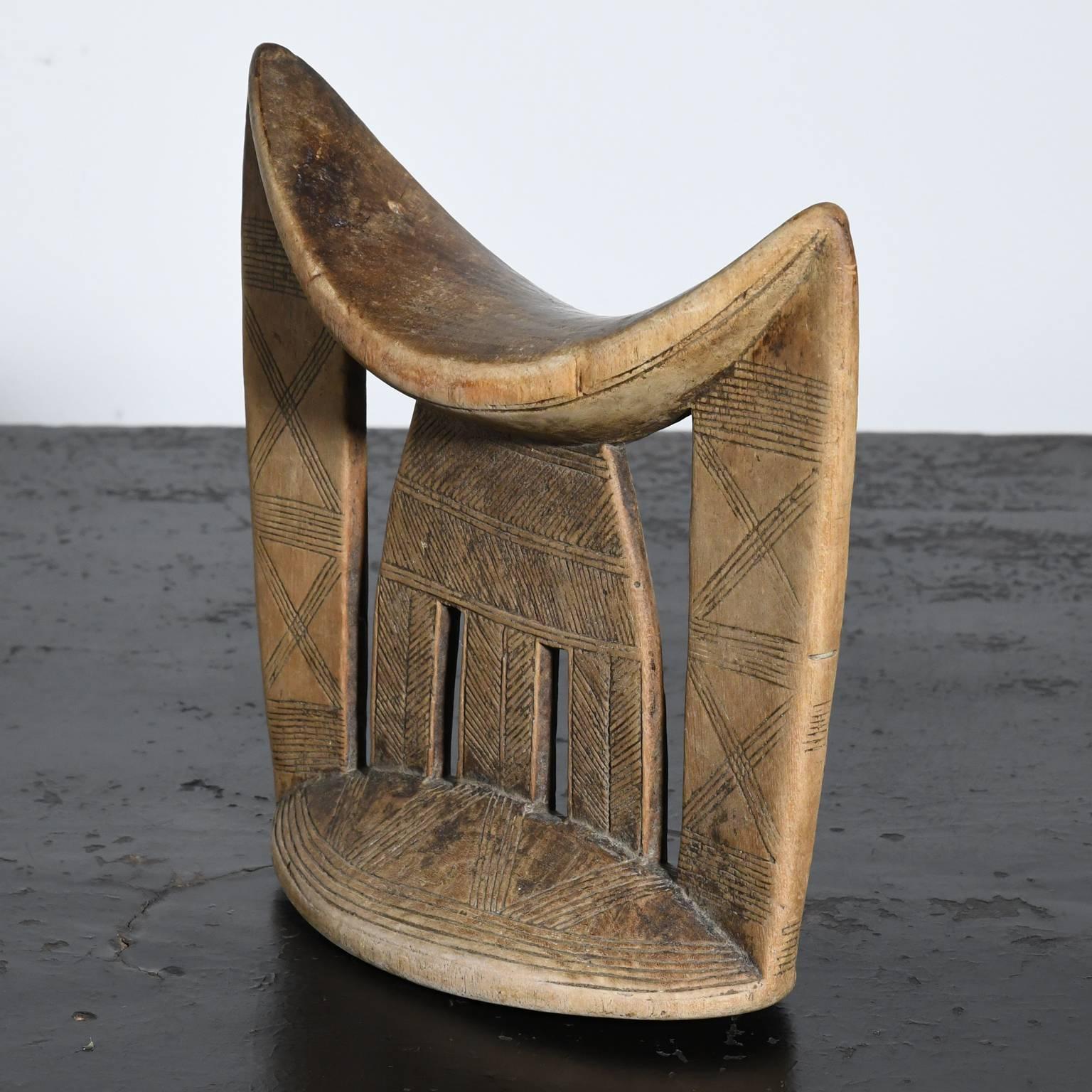 This early 20th century tribal art headrest with incised decorative lines and rich patina is from the Sidamo people of Ethiopia. 
The Sidamo live between Awasa town in the north and Dilla town in the south, spread out in a cone-shaped area of the