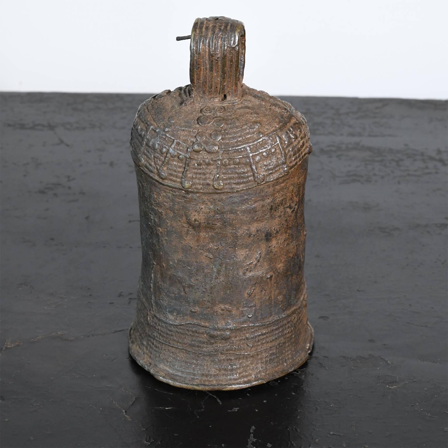 Traditionelle Stammesglocke aus Bronze vom Volk der Igbo in Westafrika. Hergestellt im Wachsausschmelzverfahren durch die Igbo- oder Igala-Metallschmiede. Die Glocken der afrikanischen Stämme wurden für eine Vielzahl von Zwecken verwendet, z. B. um