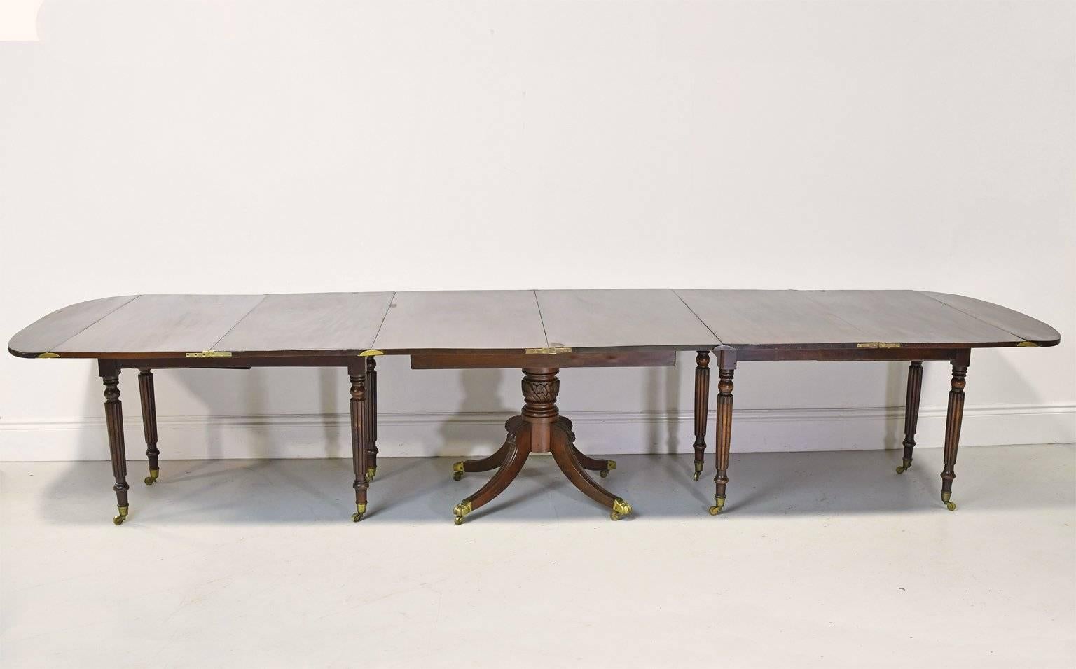 From Malcolm Forbes' estate Timberfield, an elegant and long mahogany dining table with three sections, American, circa 1850. The rectangular top above turned central-column base on splayed legs, with eight additional turned leg supports and three