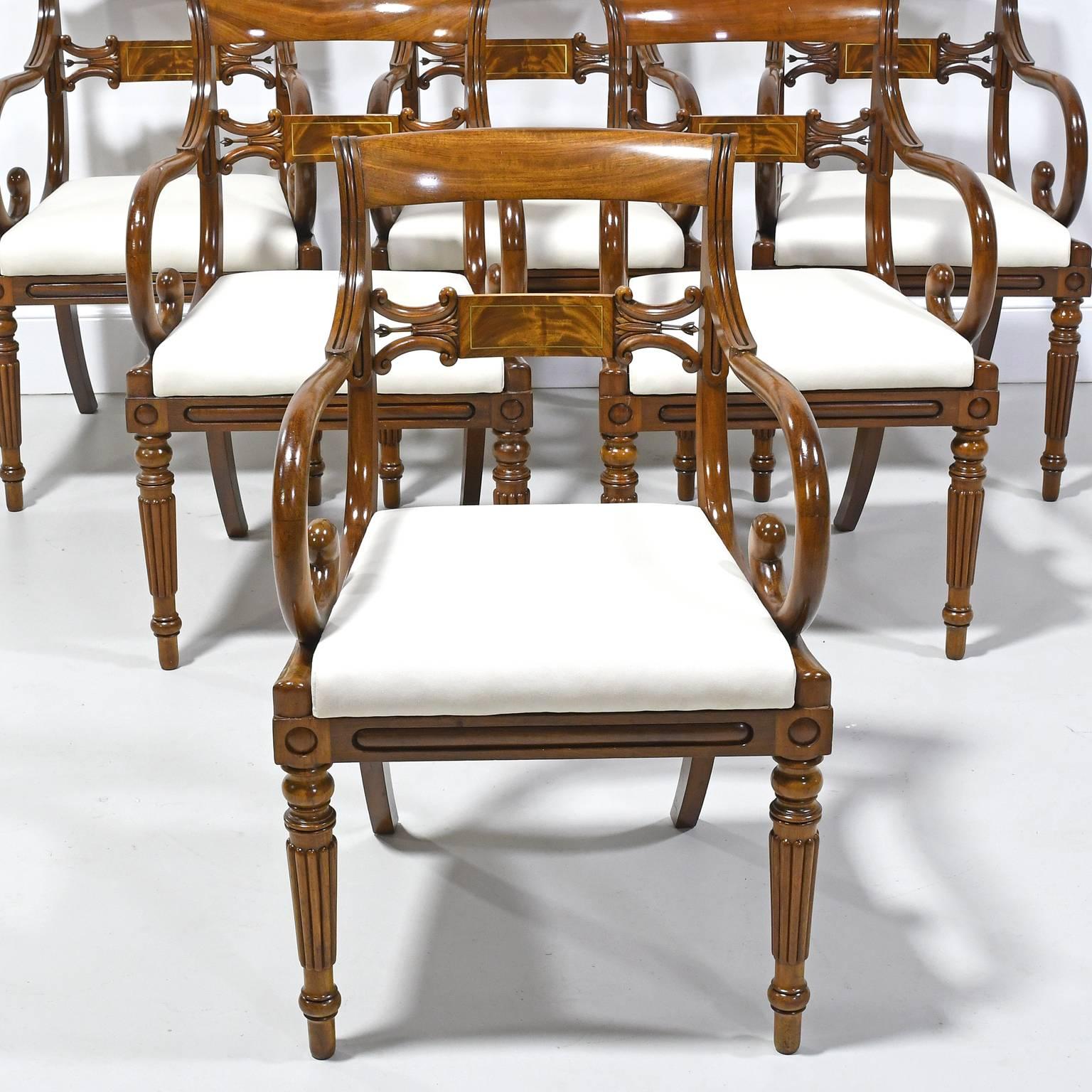 An exquisite set of six Empire /Neoclassical armchairs from the reign of Karl Johan with mahogany frame and upholstered slip seat, featuring scrolled arms, carved chair rail with line inlaid brass, and turned & reeded front legs. Sweden, circa