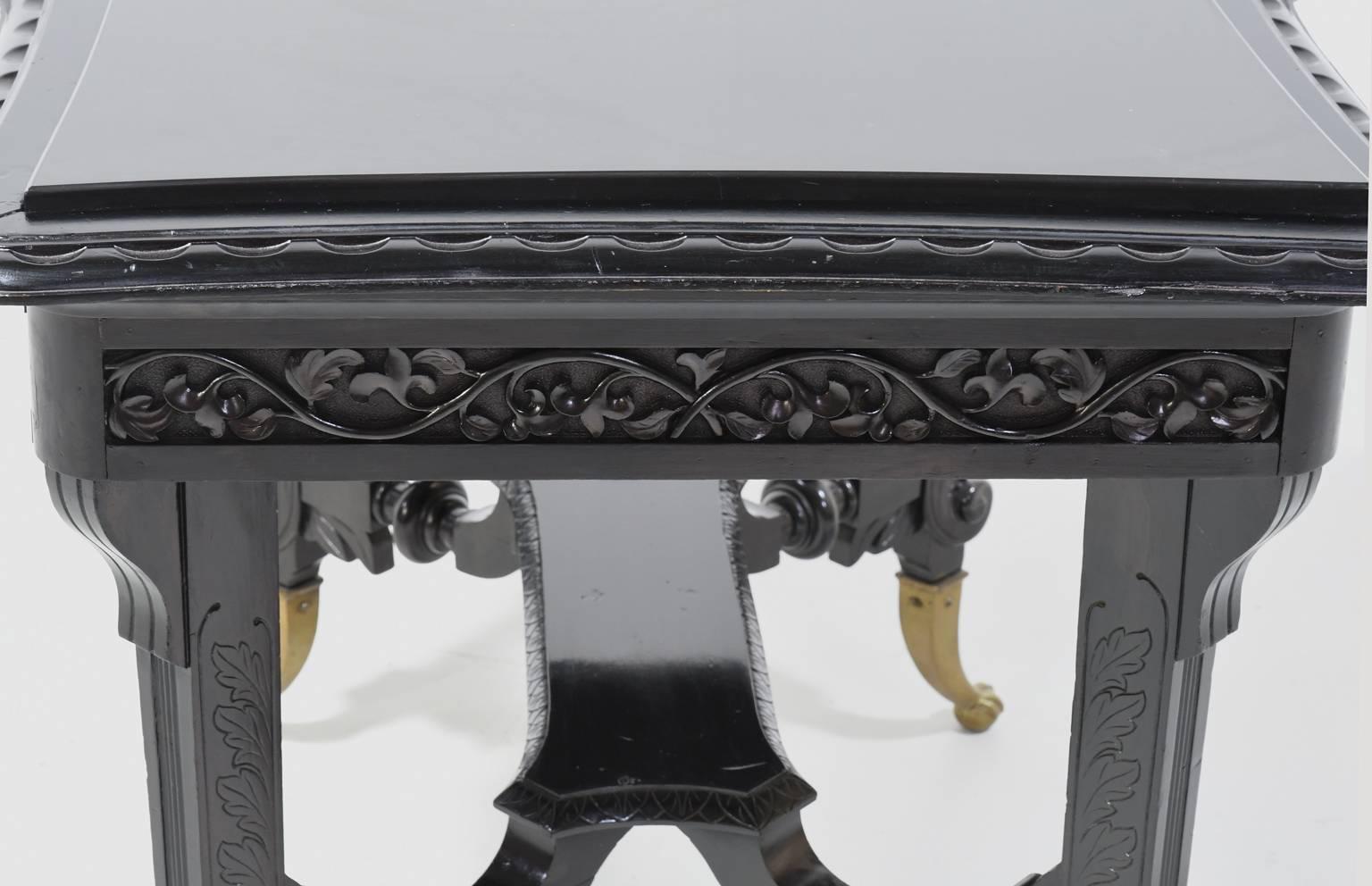 Late 19th Century Aesthetic Movement Centre Table in Carved Ebonized Wood with Brass Feet, c. 1870