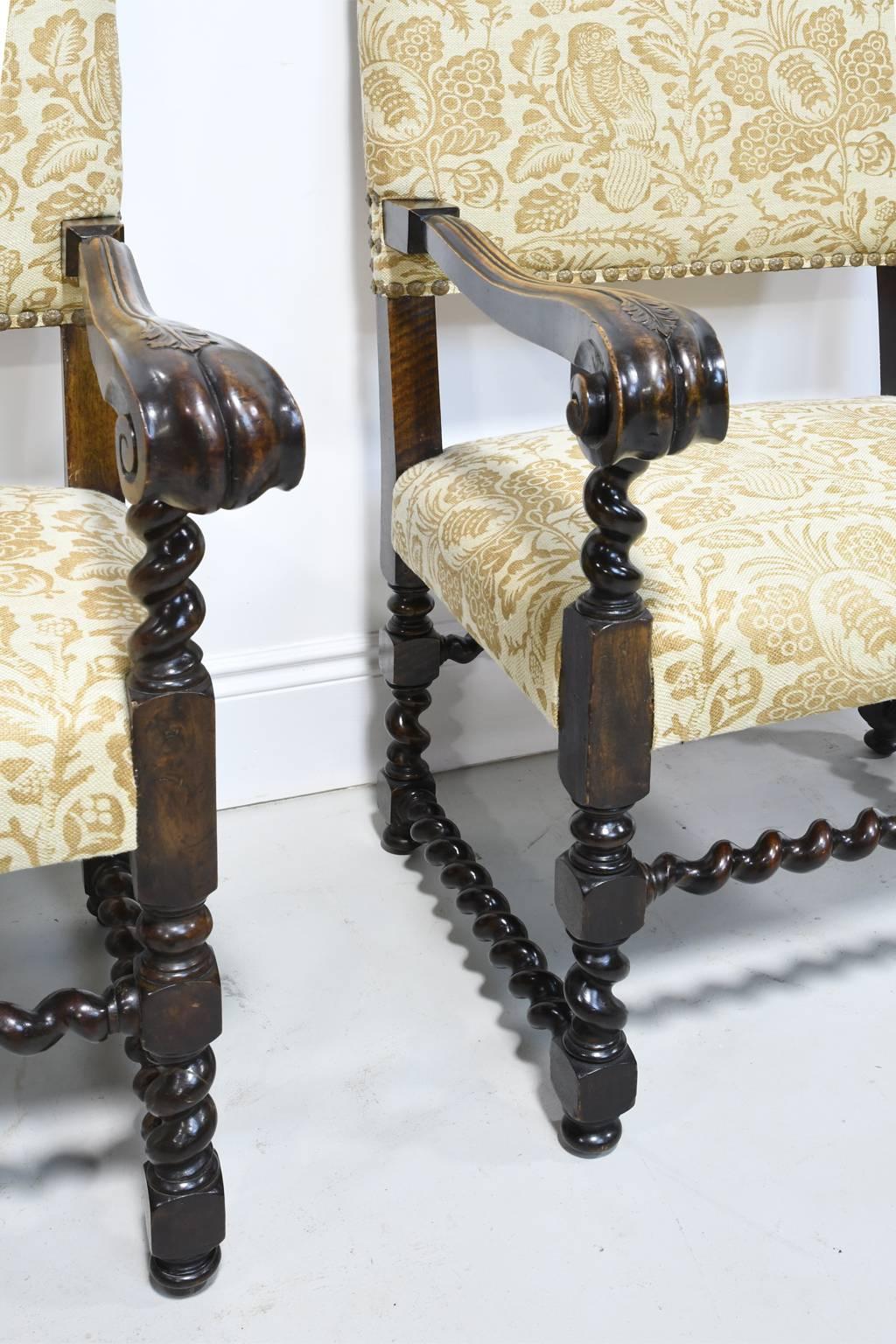 A fine pair of Jacobean Style throne chairs from the late 1800s with carved royal plumes, block and barley turnings, and upholstered back and seat. A very similar throne chair is seen in the new PBS series 