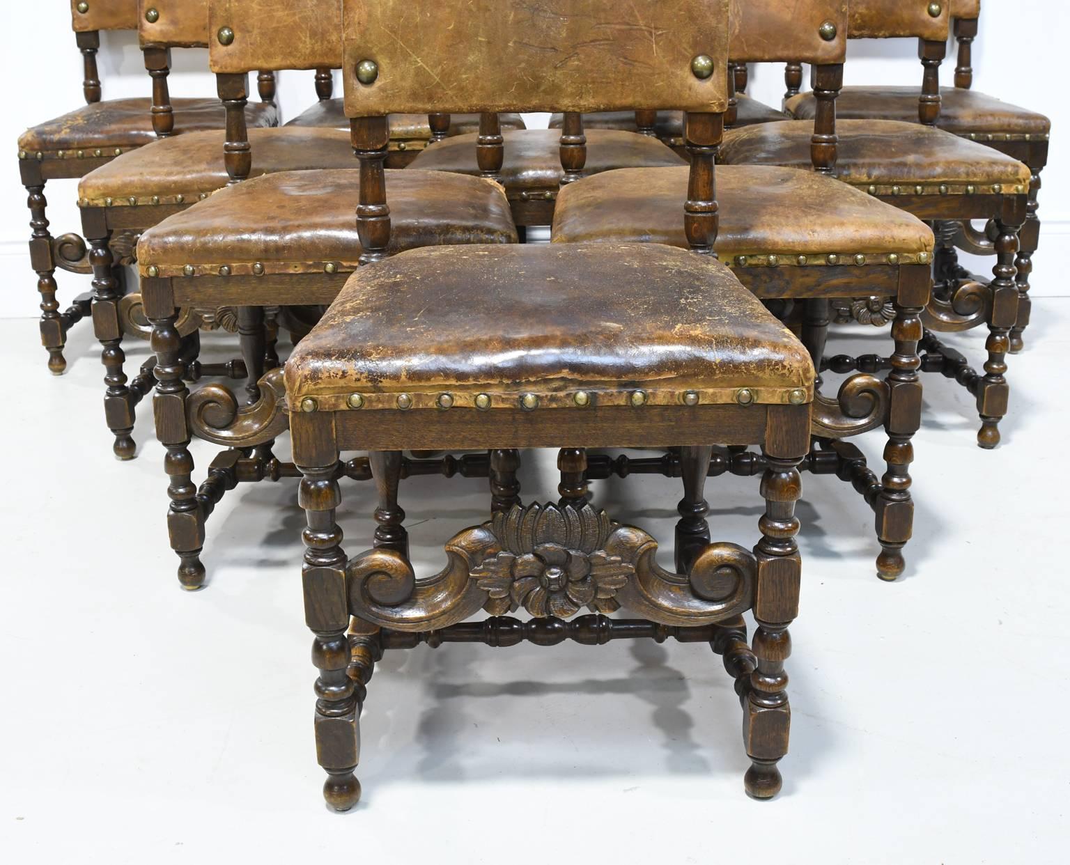 From the Belle Époque period, a set of ten exceptional Renaissance style Italian dining chairs in walnut with large comfortable seats and backs upholstered in the original brown leather, bordered with large, decorative brass nailheads. Legs are