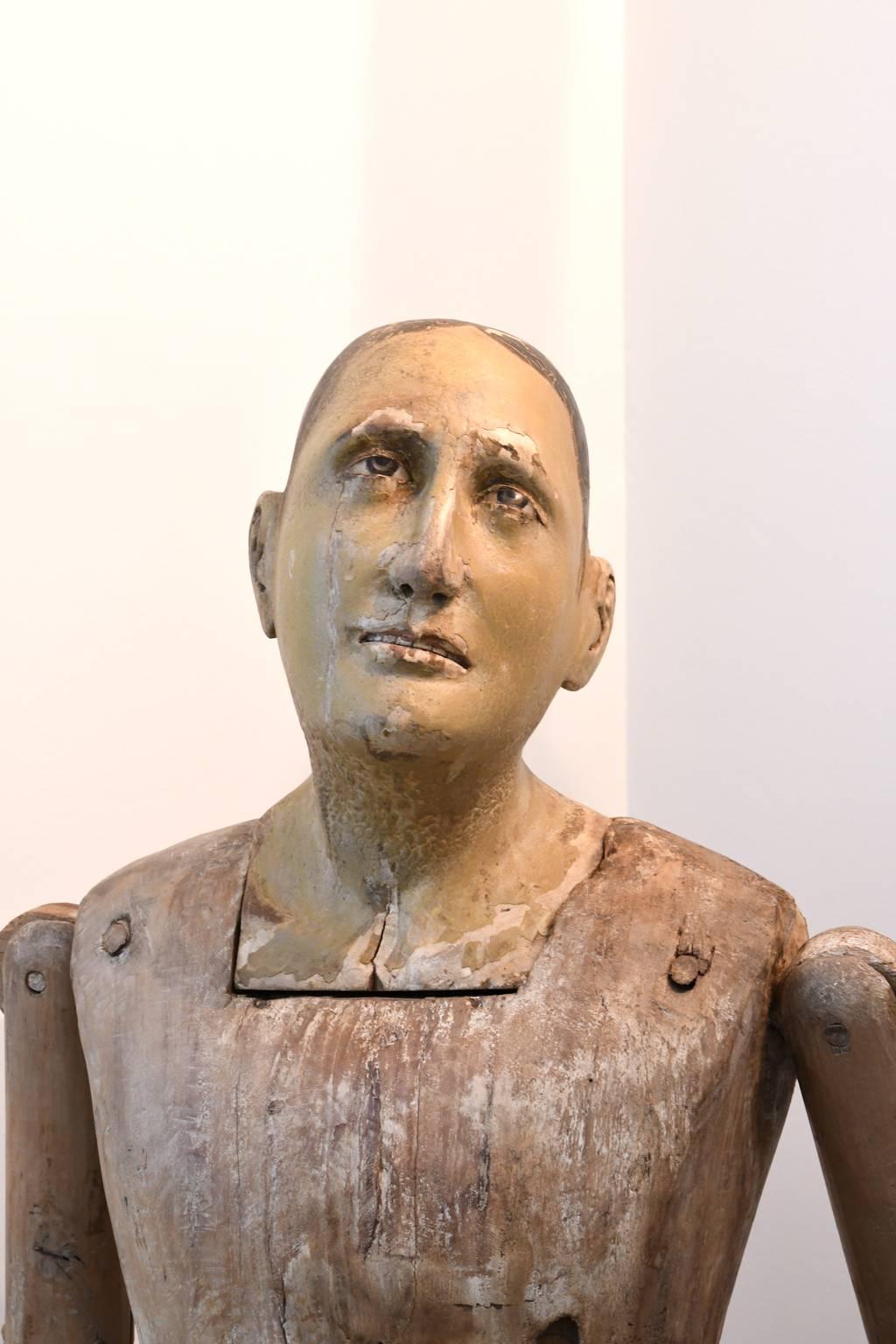 Una estatua colonial española muy fina de un santo masculino en madera tallada y policromada. El rostro del santo tiene una expresión beatífica y los ojos son de cristal. Con brazos y manos móviles, esta estatua habría estado vestida adecuadamente