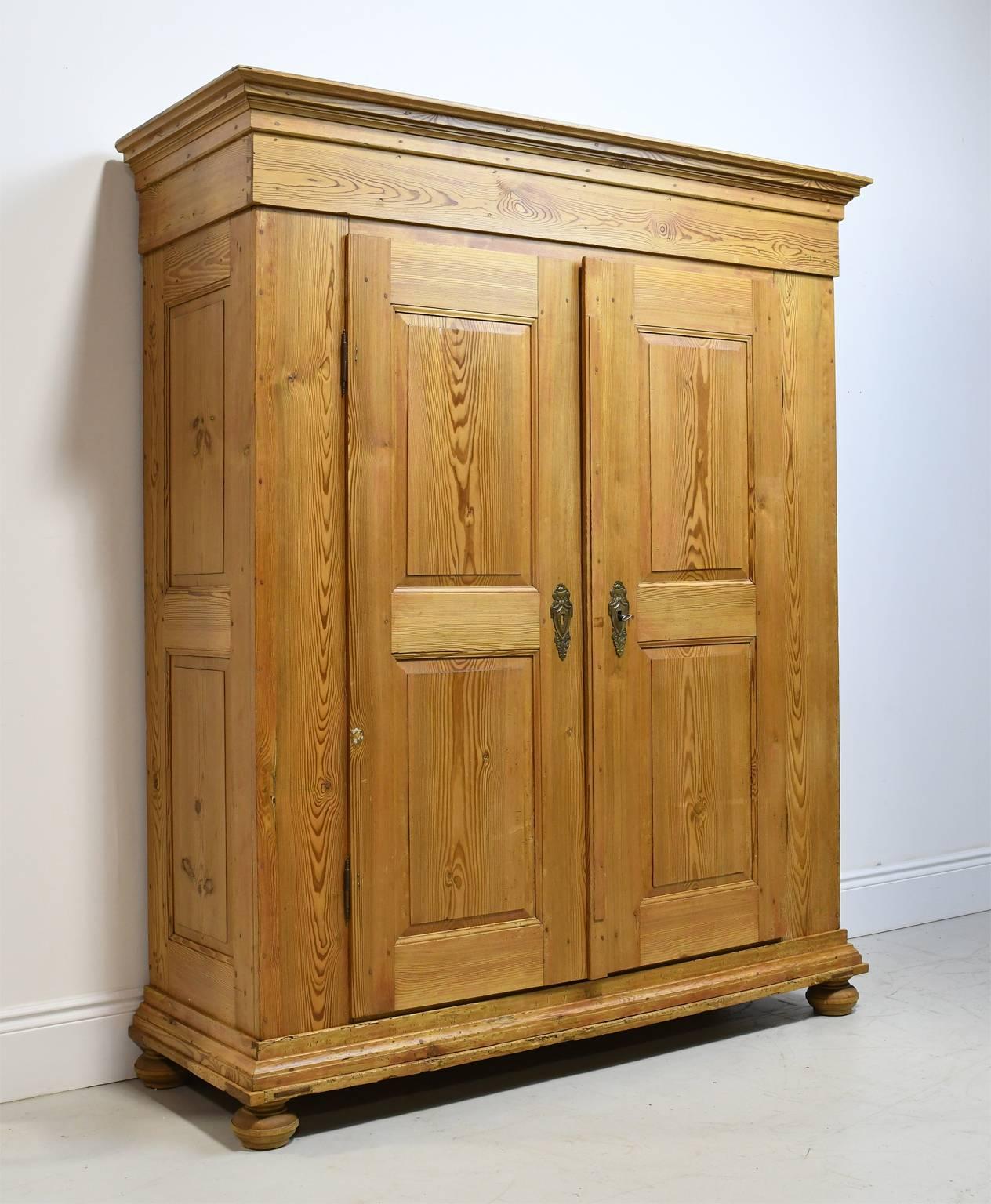 This exceptionally well-made armoire in a type of pine with a height pitch content called "kiefer", is constructed with pegged mortice and tenon joinery along with dovetail joints. All of the moldings are fastened to the frame with wooden