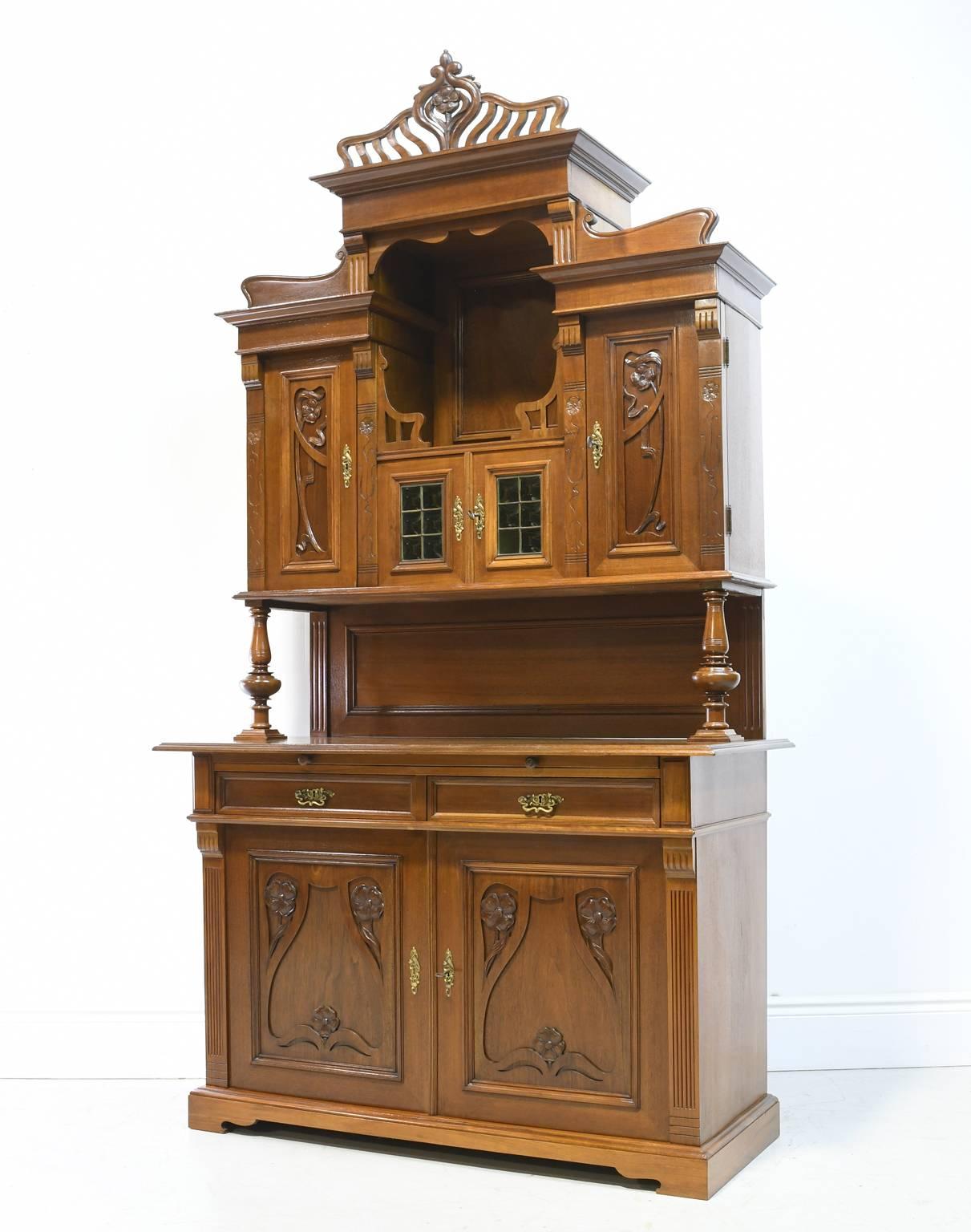 A  beautiful late 19th or early 20th century Art Nouveau buffet with the quintessential organic motifs that exemplify the Art Nouveau movement, including carved cyma curves, and floral & foliate carvings. Features custom curved tinted glass with
