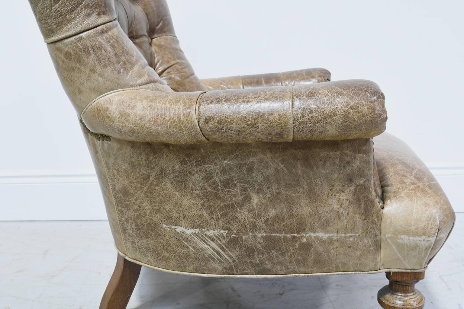 20th Century Worn Brown Leather Club Chair with Scrolled Arms, Tufted Back and Turned Feet