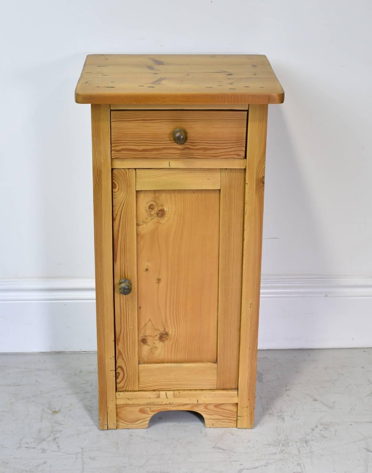 A charming pot cupboard or nightstand in pine with one drawer above the cabinet door that opens to an interior shelf. Has original brass pulls. Northern Europe, circa 1920.

Measure: 16