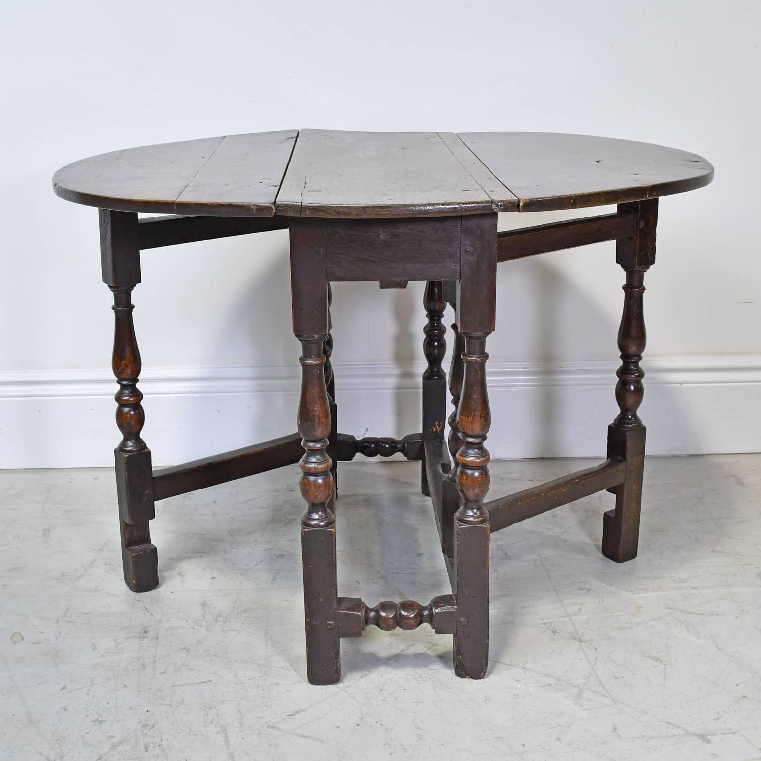 A diminutive rustic gateleg dining table in oak with drop leaves that open to a nearly round top, with turned legs that pull-out and provide support and tuck away when not in use. Scandinavian or English, circa late 1700s.
A perfect eating table for