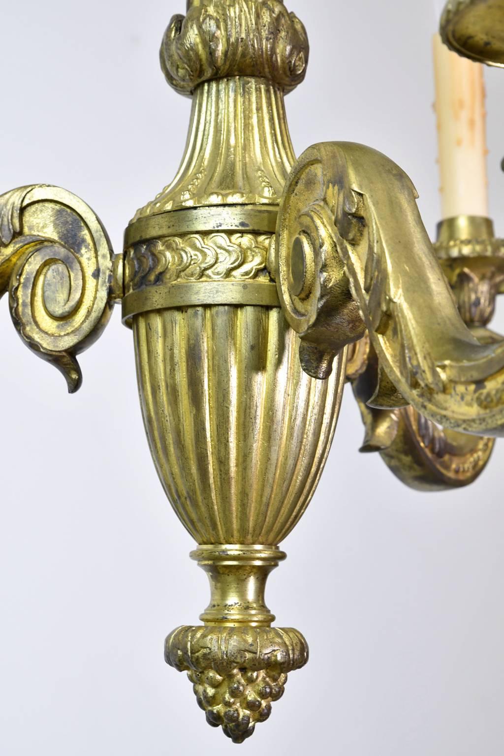 A lovely French Belle Époque chandelier in bronze doré in the style of Louis XVI with three lights, France, circa 1900. 
A beautiful accent in a small foyer, powder room, or a small dining area!
Measures: 18 1/4