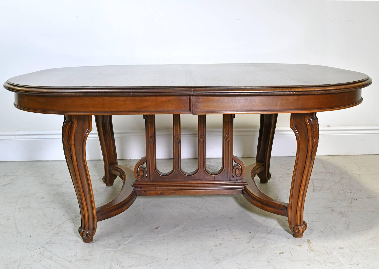 A beautiful Belle Époque coffee table in walnut featuring a racetrack top, carved cabriole legs with scrolled feet that are joined by an 