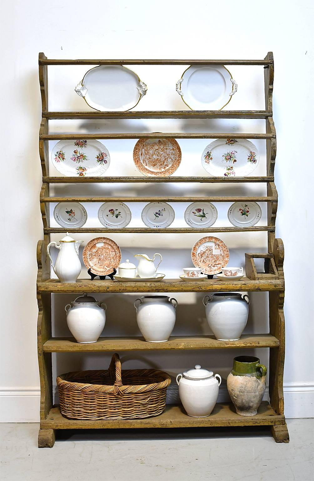 A very rare German Baroque cupboard with open bottom shelving below open dish rack offering enormous opportunity for showcasing a porcelain, glass collection or kitchenalia. Has a lovely carved silhouette and antique yellow ochre paint, that is