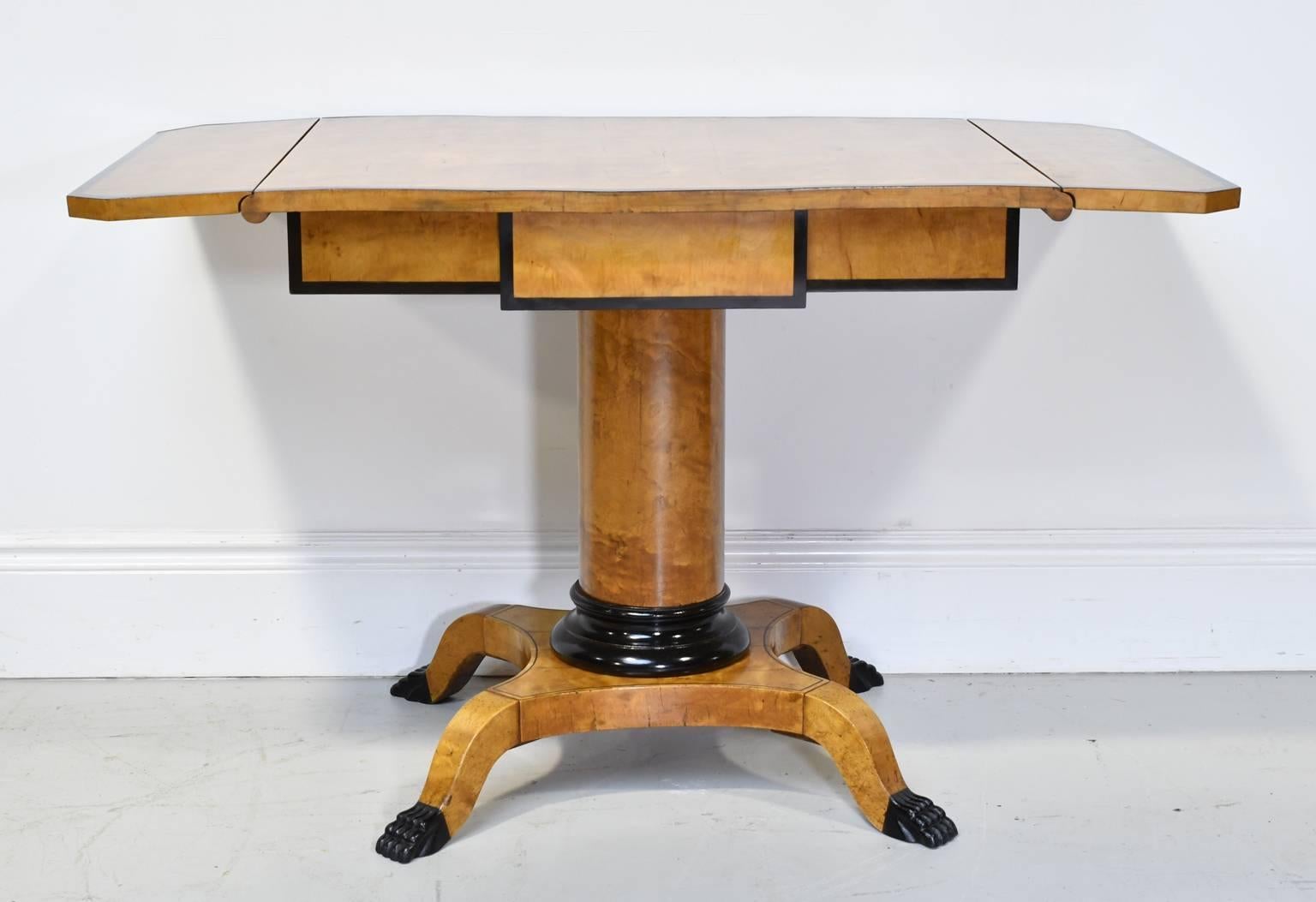 A handsome and contemporary looking Biedermeier desk or salon table from the reign of Karl Johan of Sweden. Top has drop leaves extending the top to 47 1/4