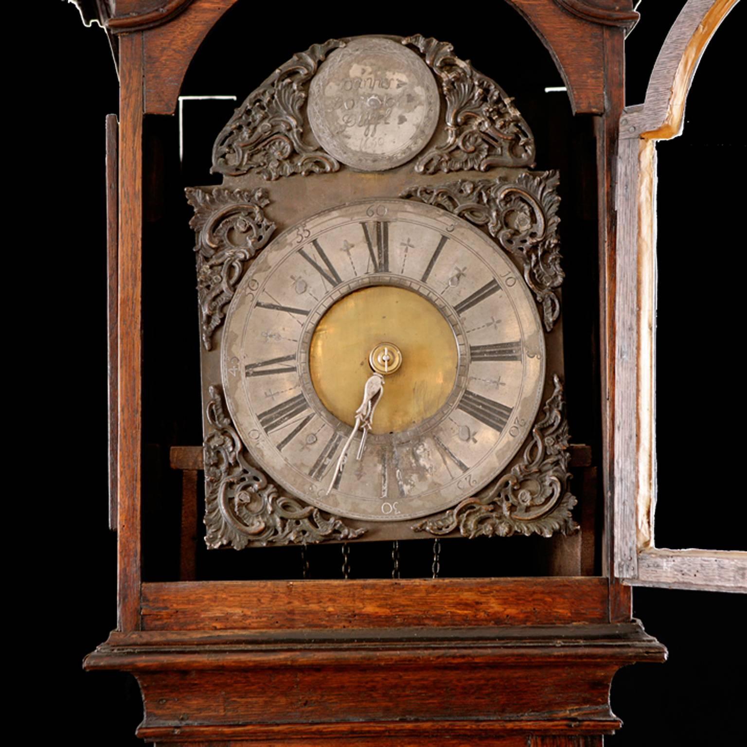 A very beautiful and early Louis XIII tall-case clock whose movement includes a single weight chain fall with a 24-hour wind, with a pewter and brass dial with arabesque embellishments in relief around dial and around top circular plate inscribed