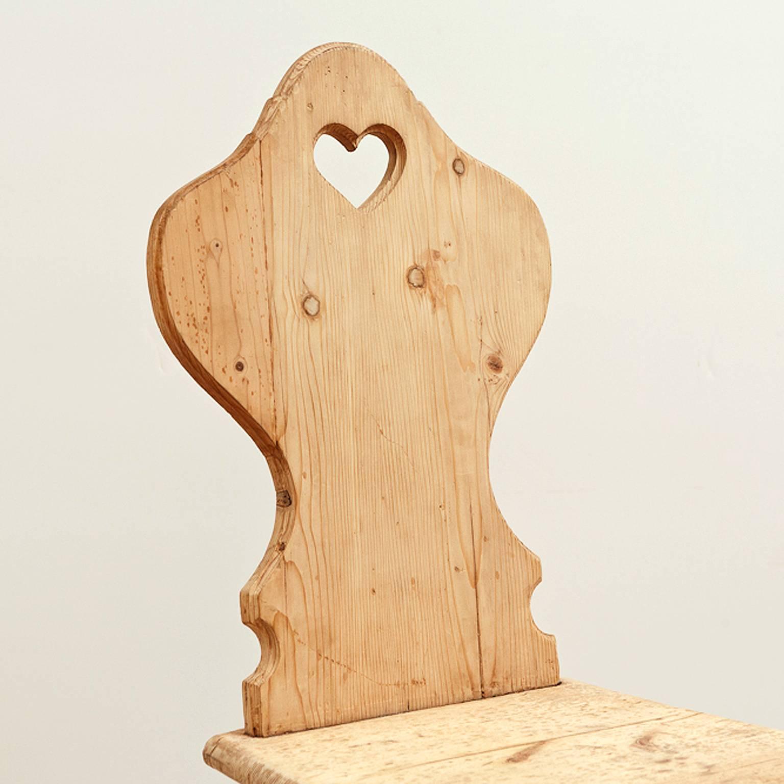 A very charming Alpine farmhouse chair in pine from the Tyrollean region of Austria with a heart-shaped, carved opening embellishing the balloon-back, with tapered square seat resting on turned legs, Austria, circa mid-1800s. 

Measure: 16