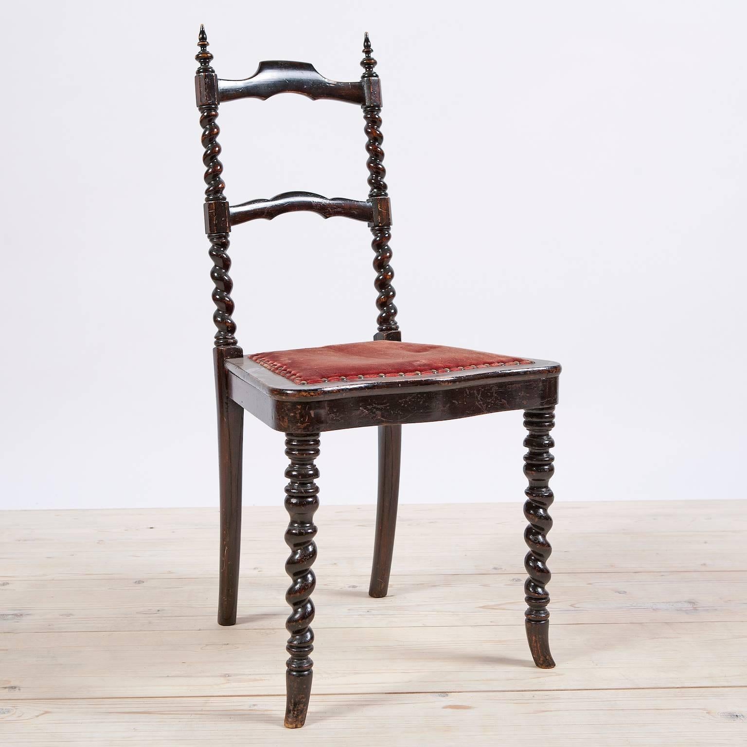 An extremely uncommon and large set of dining chairs in ebonized or black-painted wood with slat-back, steeple finials, twist turnings flanking the back and on the front legs, and upholstered seat with serpentine front, Sweden, circa