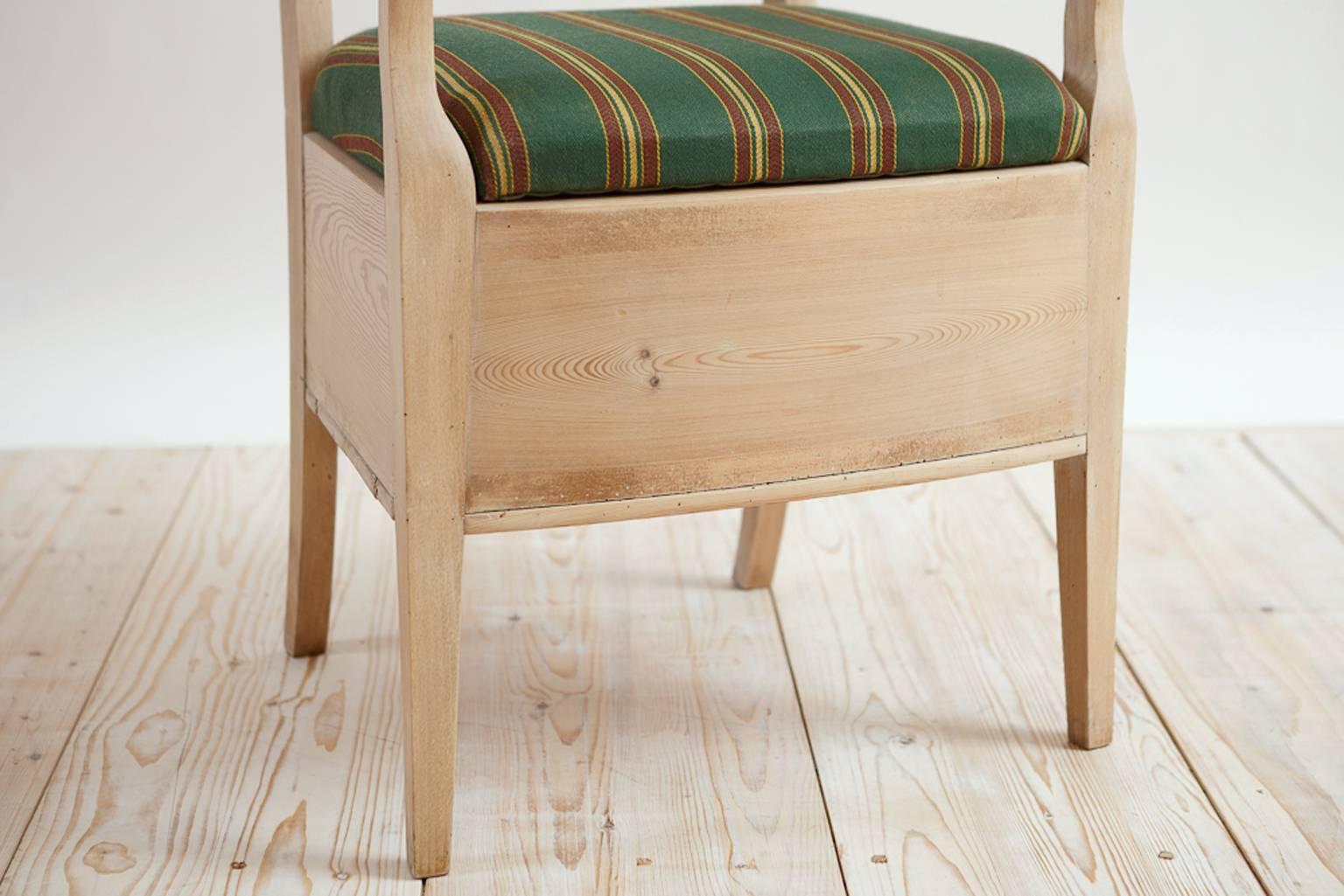 A charming and beautiful chair with an interesting place in history, this potty chair has an upholstered slip seat that lifts up to expose a round opening under which would have rested the chamber pot, with a hinged access along the back apron to