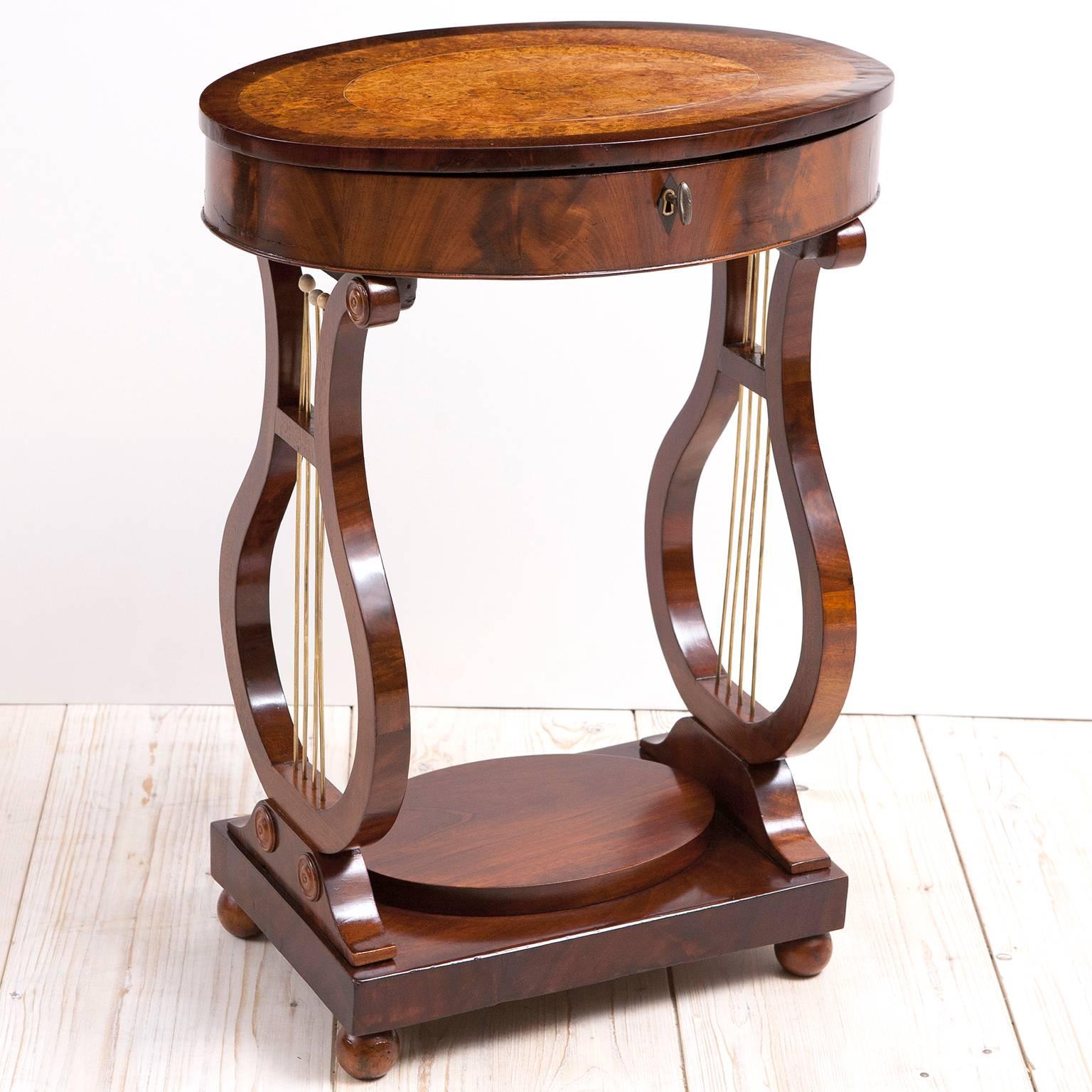 Karl Johan sewing table with lyre base, Sweden, circa 1830. 
Outstanding lyre base sewing table in French polished mahogany. Top is banded in mahogany with burled birch and line inlay of kings wood. Beautiful, complete interior featuring mahogany