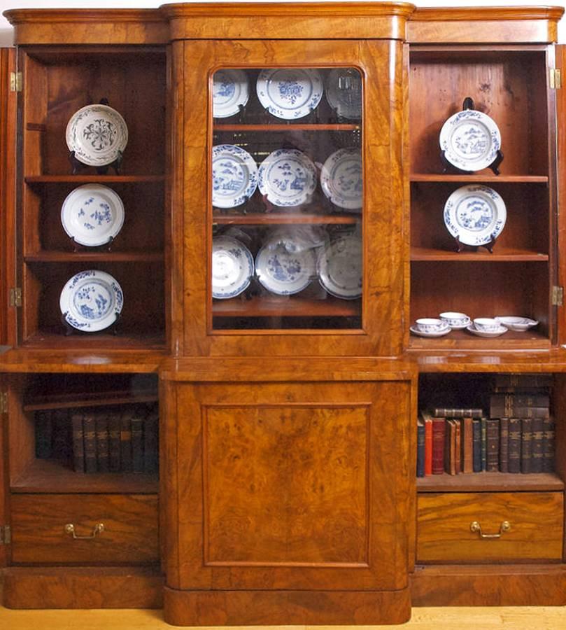 An exceptionally beautiful late English Regency (William IV) or early Victorian bibliotheque in book-matched burl walnut with three glass cabinet doors over a base with three solid paneled doors. Ample amount of storage with shelves and drawers.