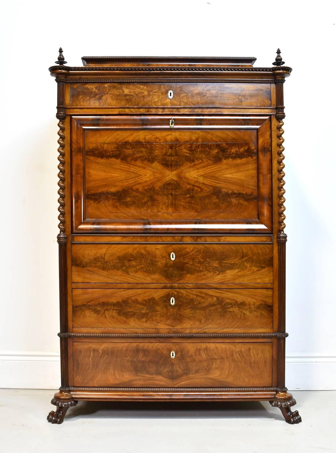 A very lovely Christian VIII secretary in fine West Indies mahogany with turned finials flanking pedestal top above top drawer, with drop-front opening to a desk with open storage area for papers surrounded by a series of fitted drawers of various