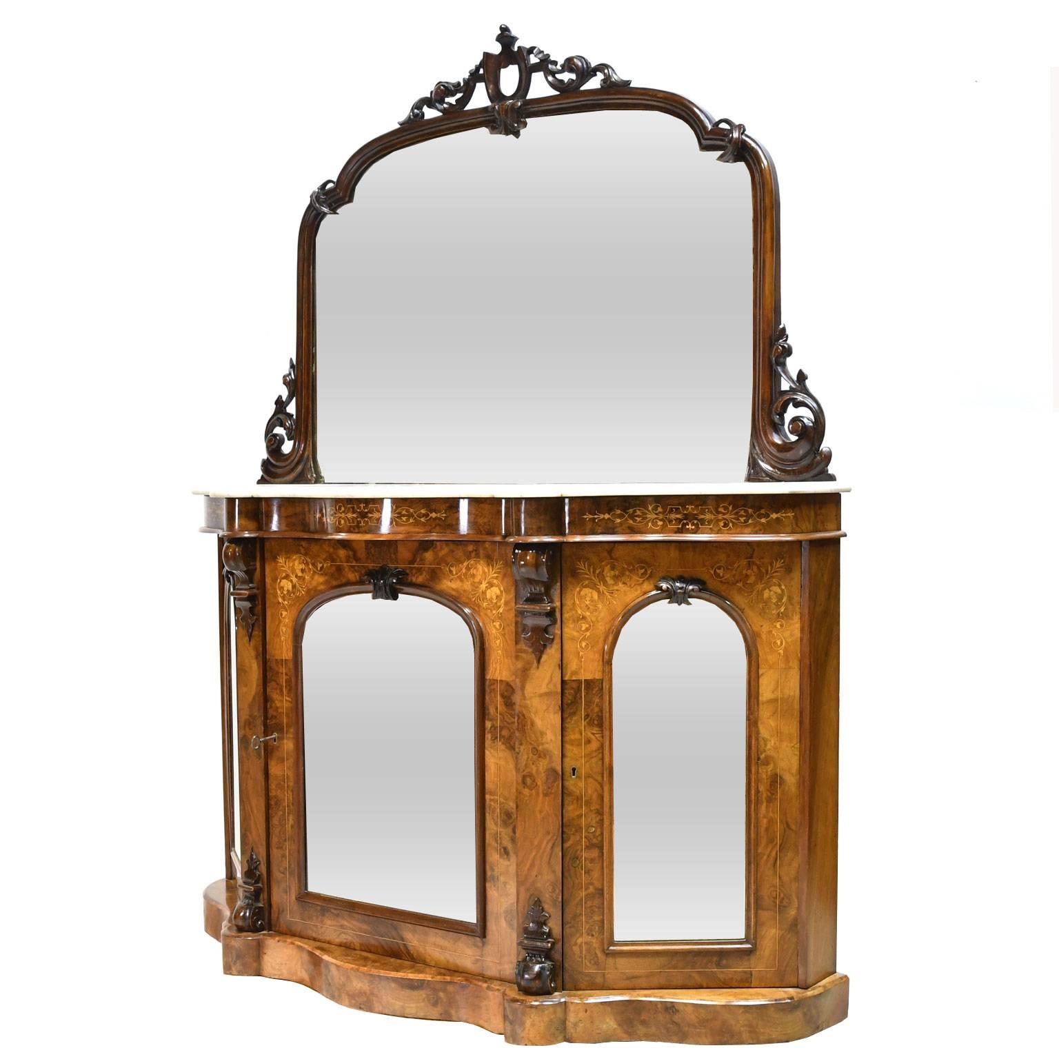 A lovely English Victorian console or credenza in burl walnut with satinwood and kingwood line inlays, with original mirrors  in carved walnut resting on original white Carrara marble top. Base offers three cabinet doors with arched mirrored panels